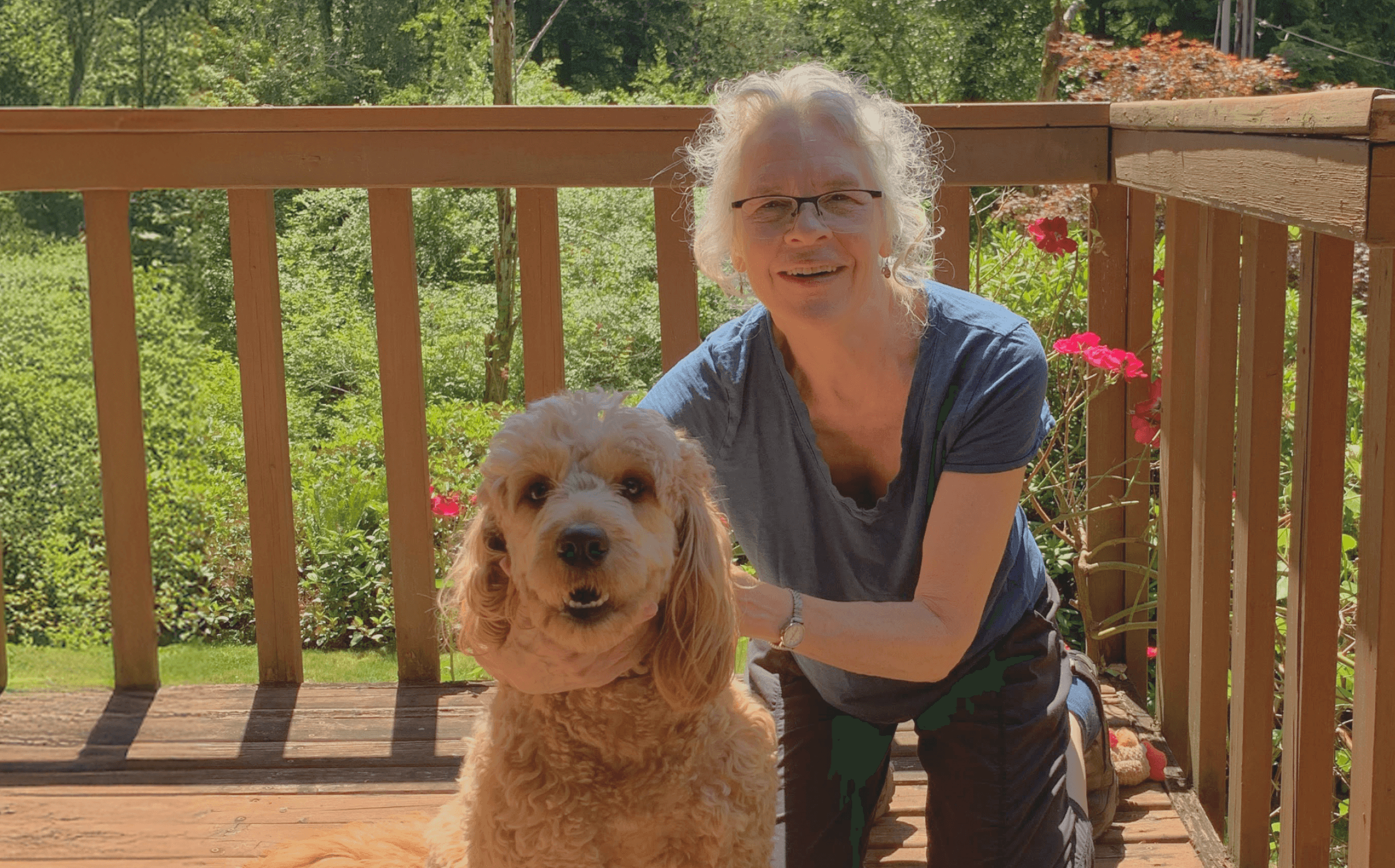 Celia standing on a porch with her dog.