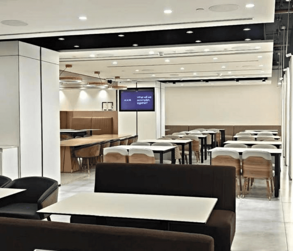 Vibrant Open Office floor with ergonomic desks, blue accents, and a communal meeting table in Boomi.