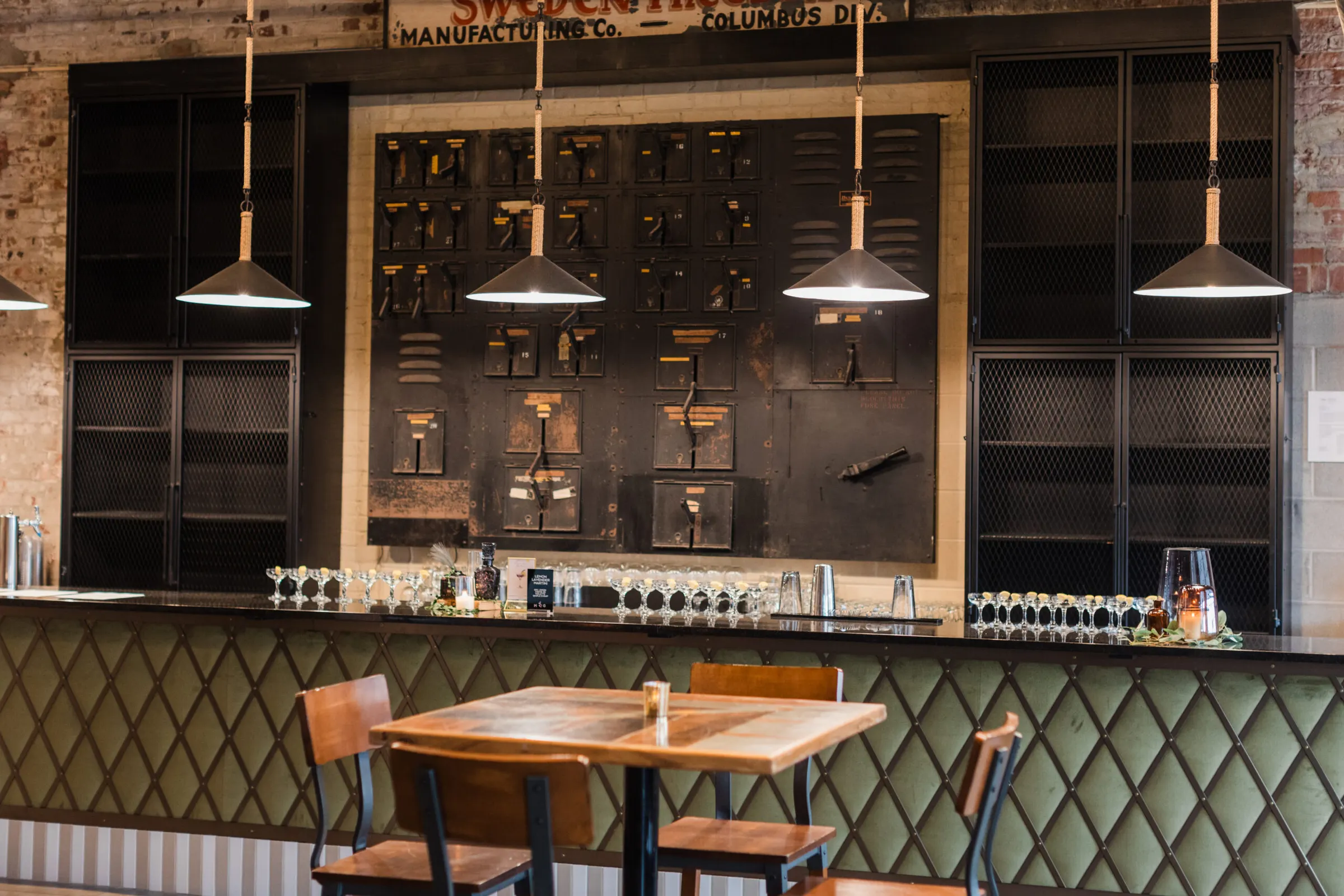 Green tile bar with pendant lights at Strongwater