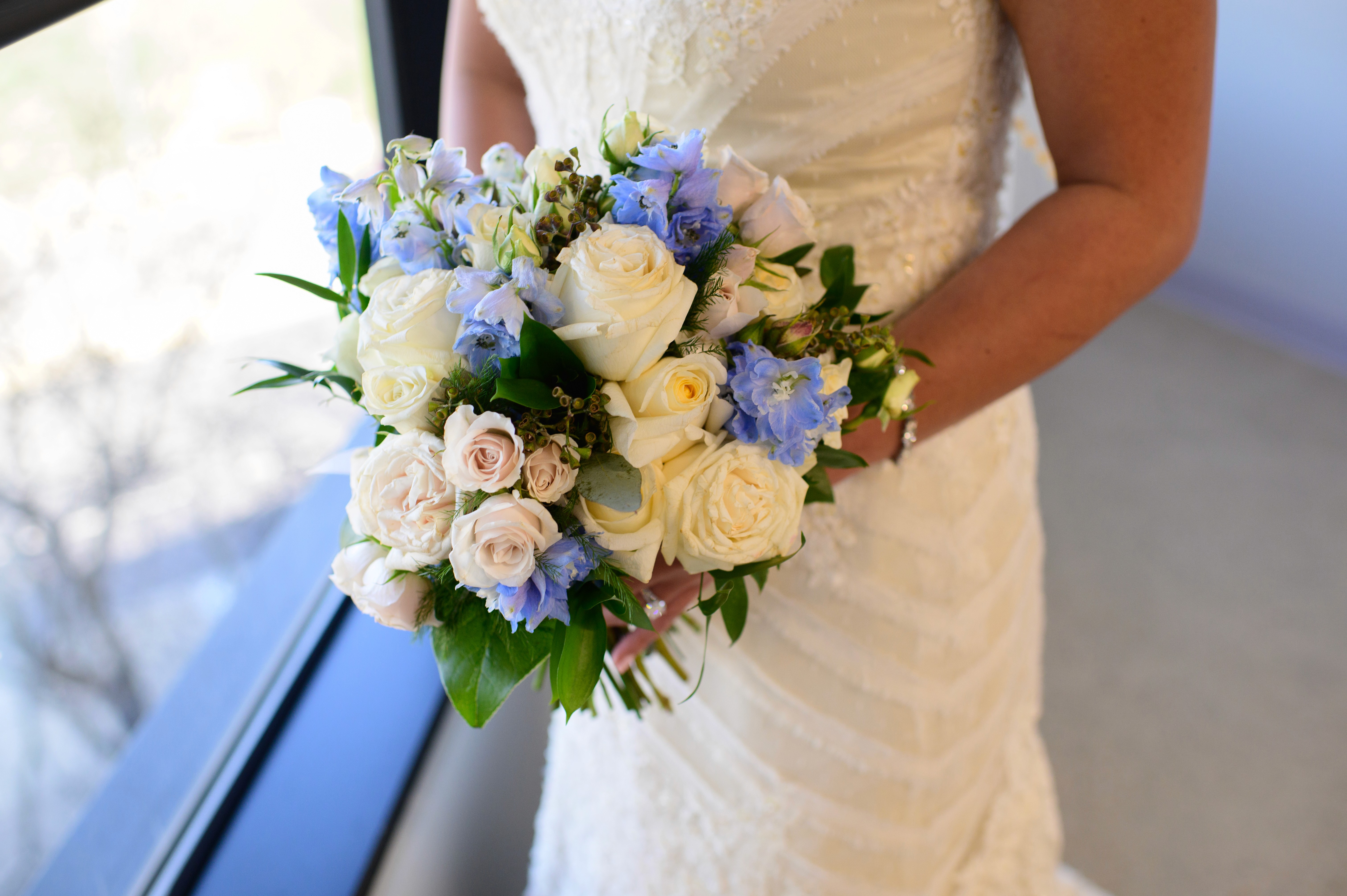 Bridal bouquet with cream roses and blue flowers, Des Moines wedding florist.