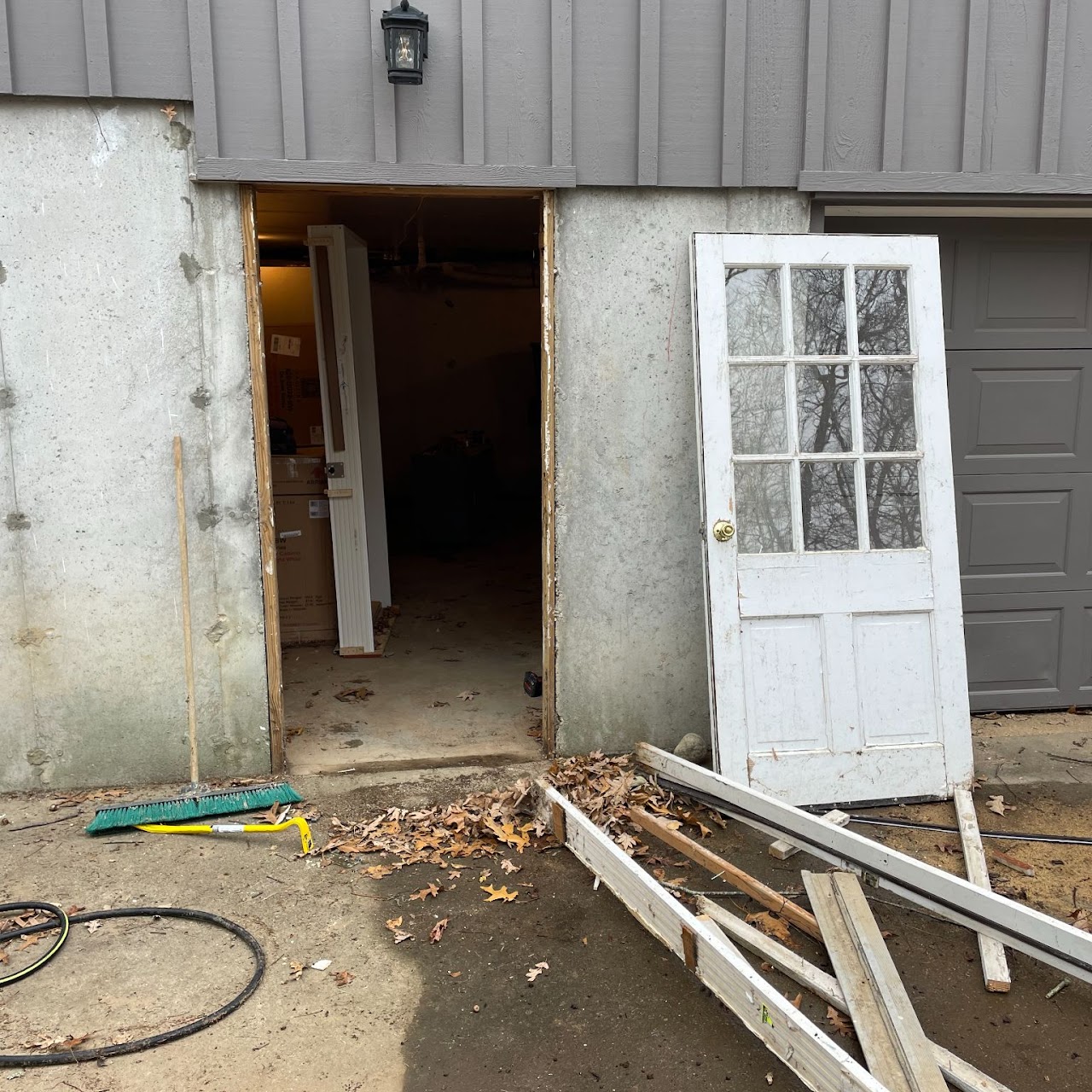 Old white door removed showing rough garage entry before replacement