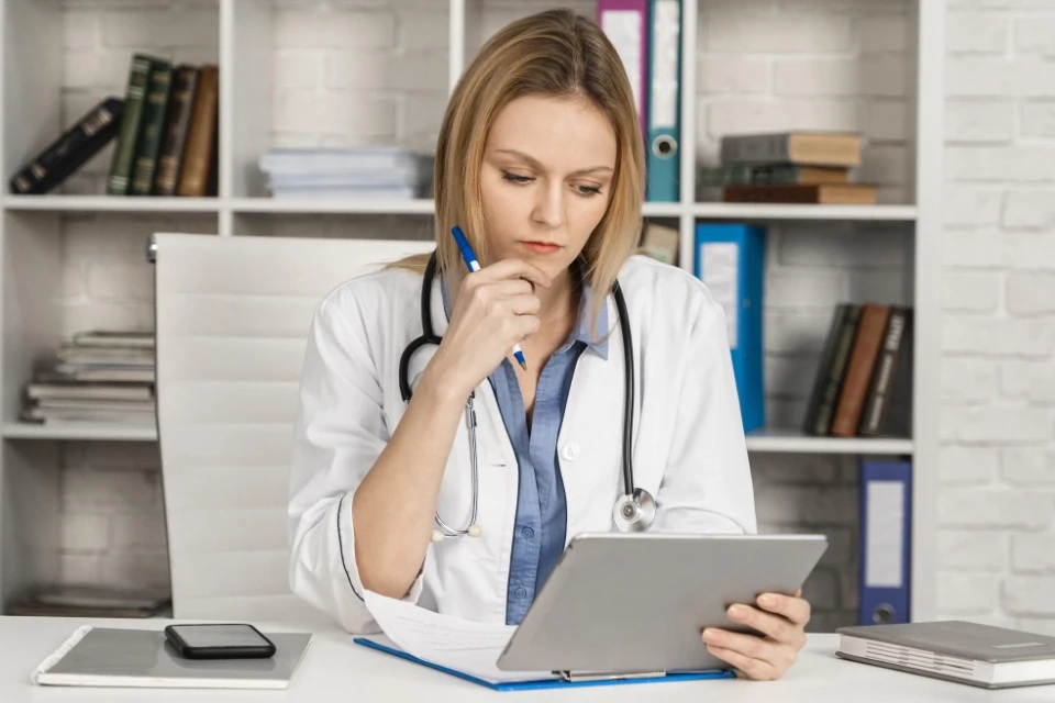 Caucasian female doctor reviewing documents.