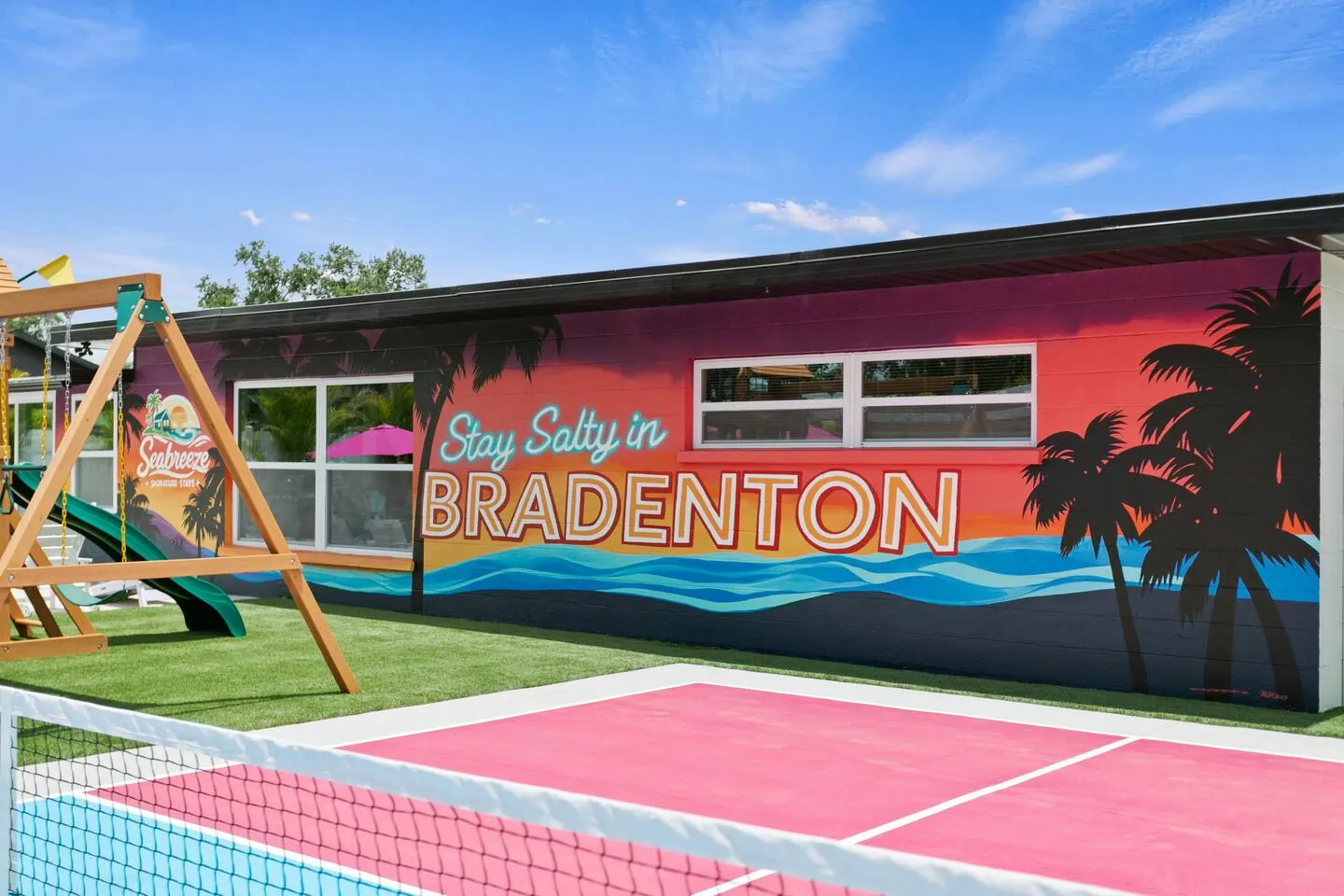 Pickleball court with playset and mural reading “Stay Salty in Bradenton” at Salty House, Bradenton, Florida