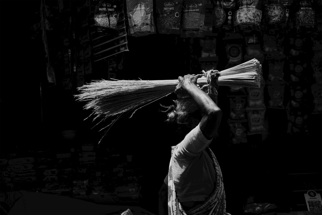 Woman carrying a bundle of brooms on her head