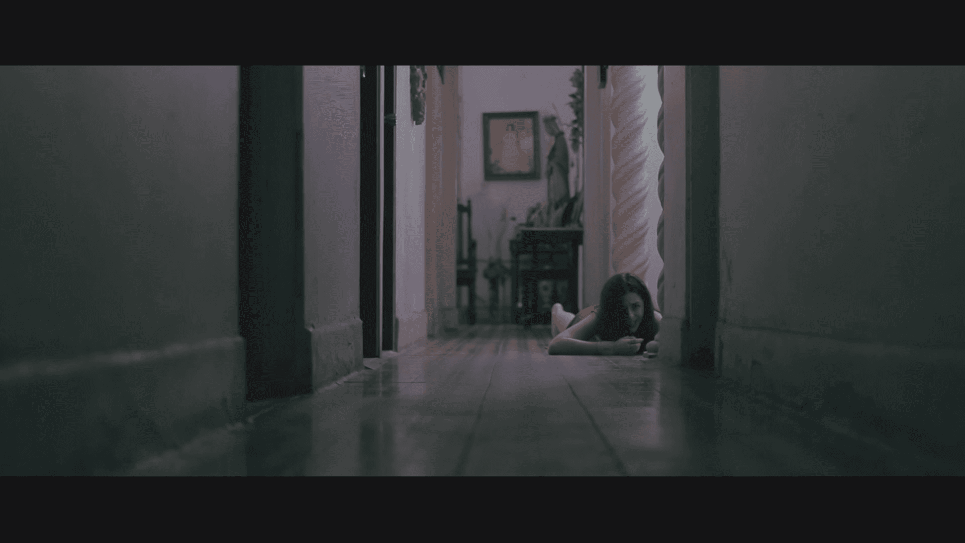 Woman in a light suit sitting thoughtfully against a terracotta wall