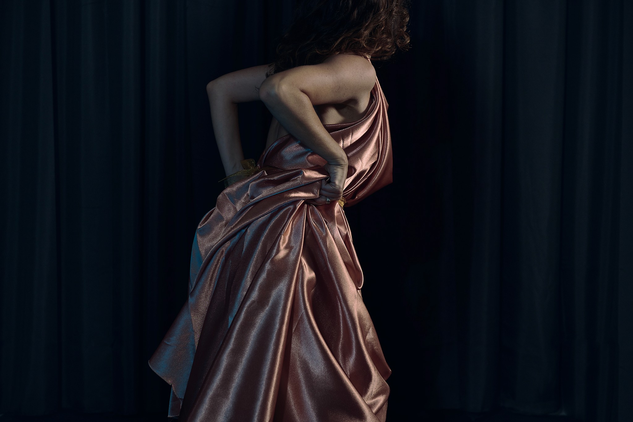 Dancer captured mid performance with artistic and expressive movements against a dark background.