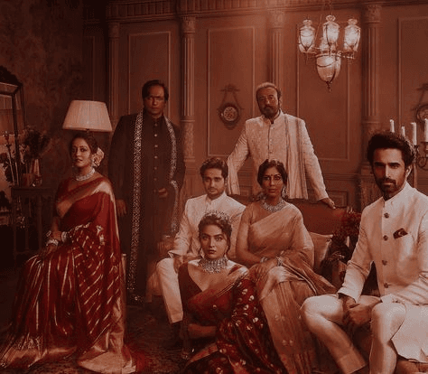 Formal, vintage-toned family portrait set in a luxurious interior, displaying coordinated traditional attire, showcasing the artistry of editorial wedding photography.