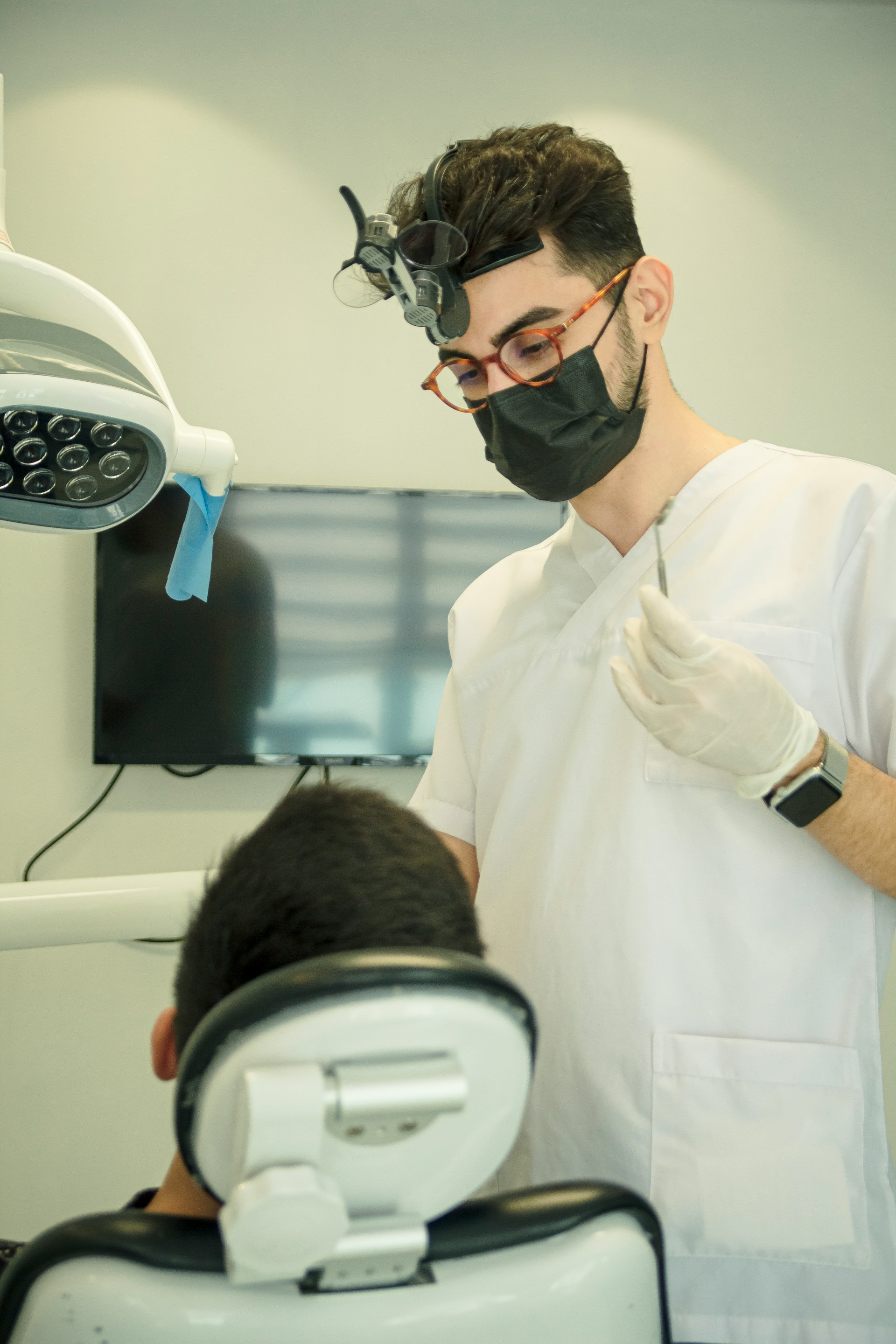 A dentist focused on patient treatment, highlighting the challenge of marketing and acquiring new clients.