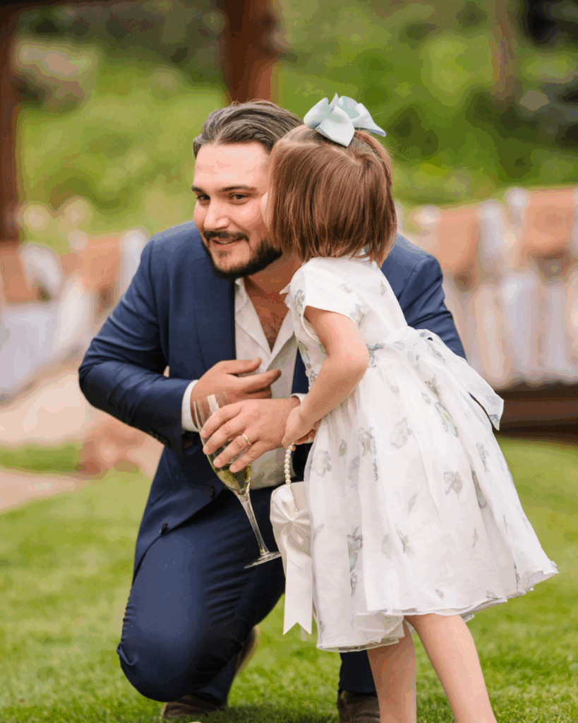 Man kneeling to hug a young girl at the reception