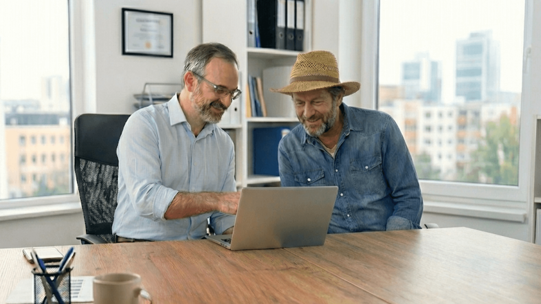 Consultor e produtor rural satisfeito analisam dados de gestão de agronegócio em notebook.