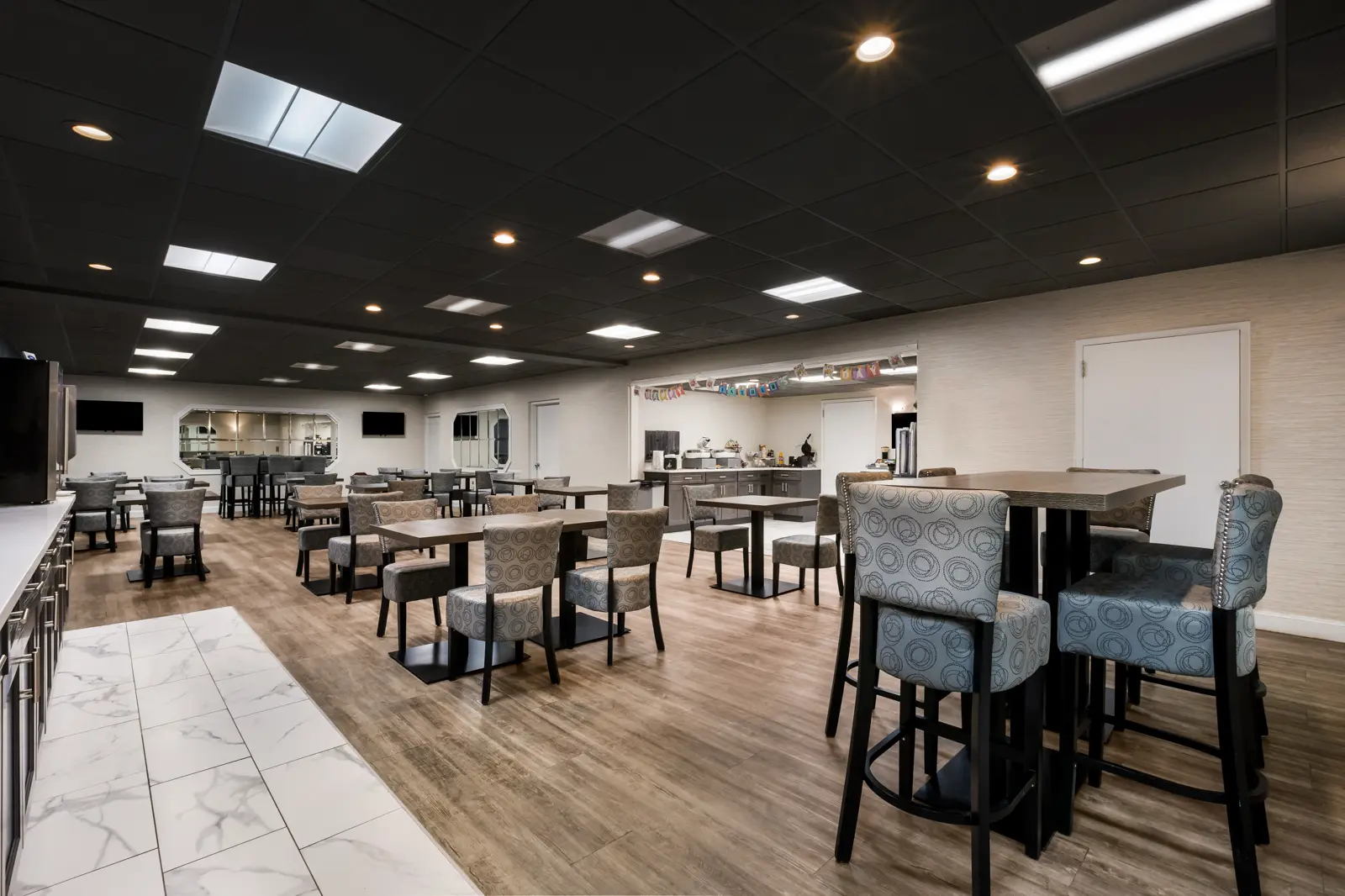 Modern, empty common dining room with tables and chairs.