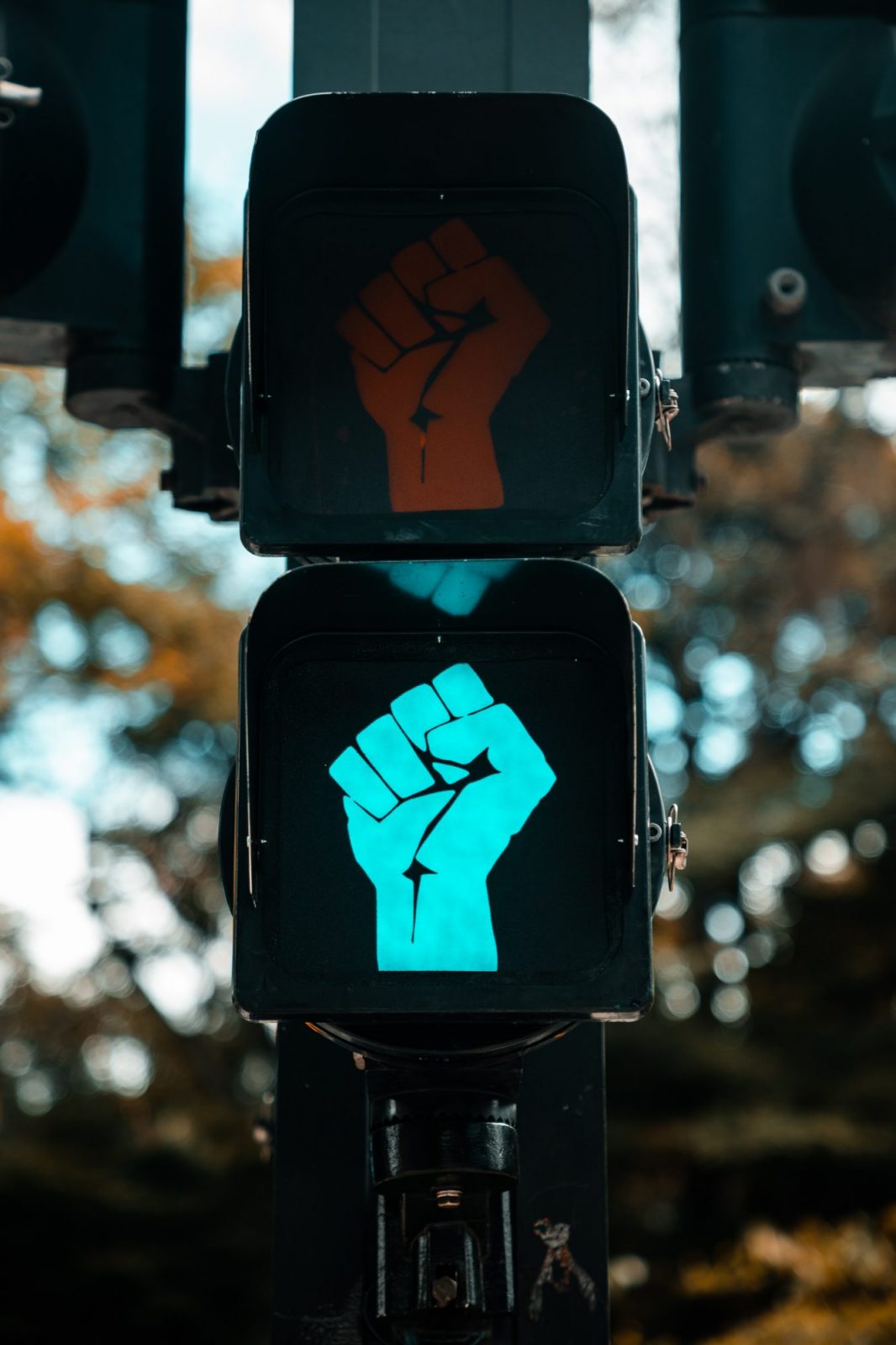 A stylized figure with a glowing blue fist symbol on a black background, resembling themes of empowerment or protest.