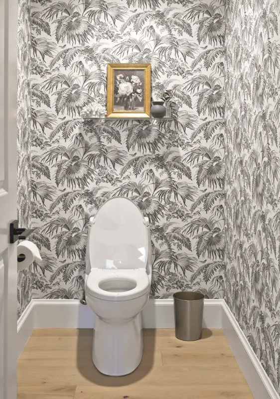 Portrait view of the powder bathroom toilet area, highlighting the patterned wallpaper and decor in the Dana Point Remodel. Photo by Todd Huge.