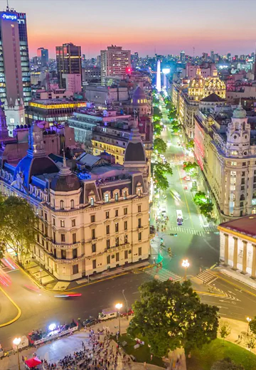 Vista aérea da cidade com edifícios residenciais e comerciais cercados por áreas verdes urbanas