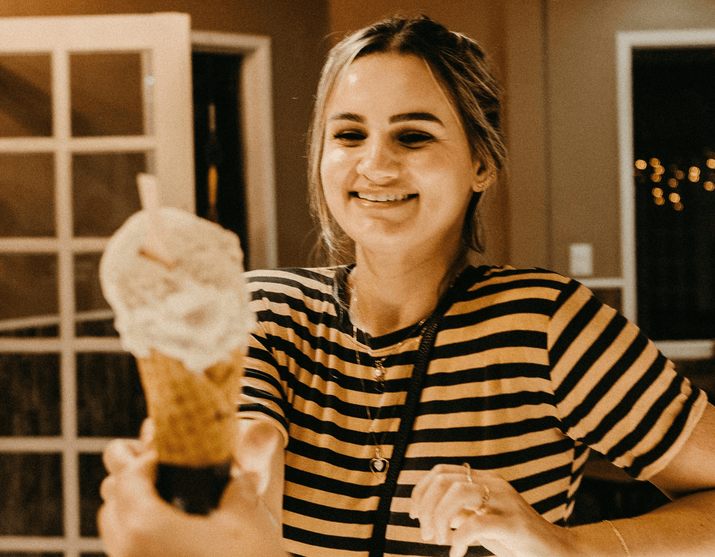 A woman eating an ice cream after winning a sale