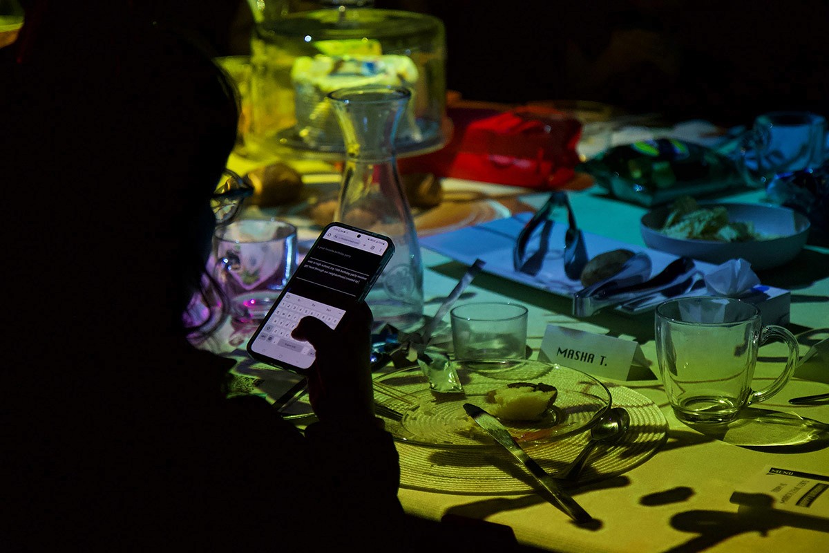 A guest answers a question on their phone. In the background, the table feels magical.