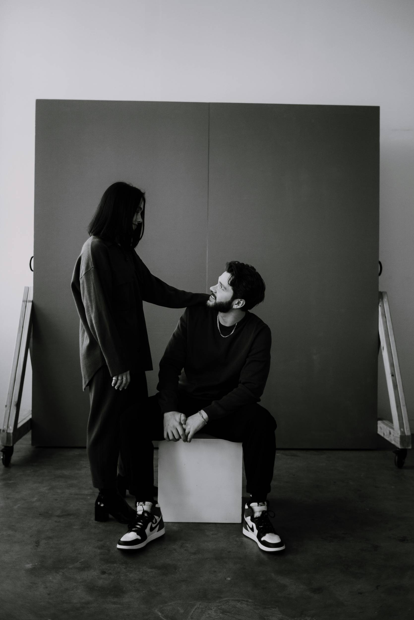 A black and white image of a couple in studio looking at each other