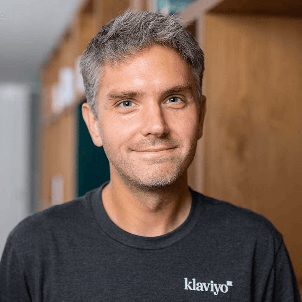 Black and white portrait of a smiling person with curly hair
