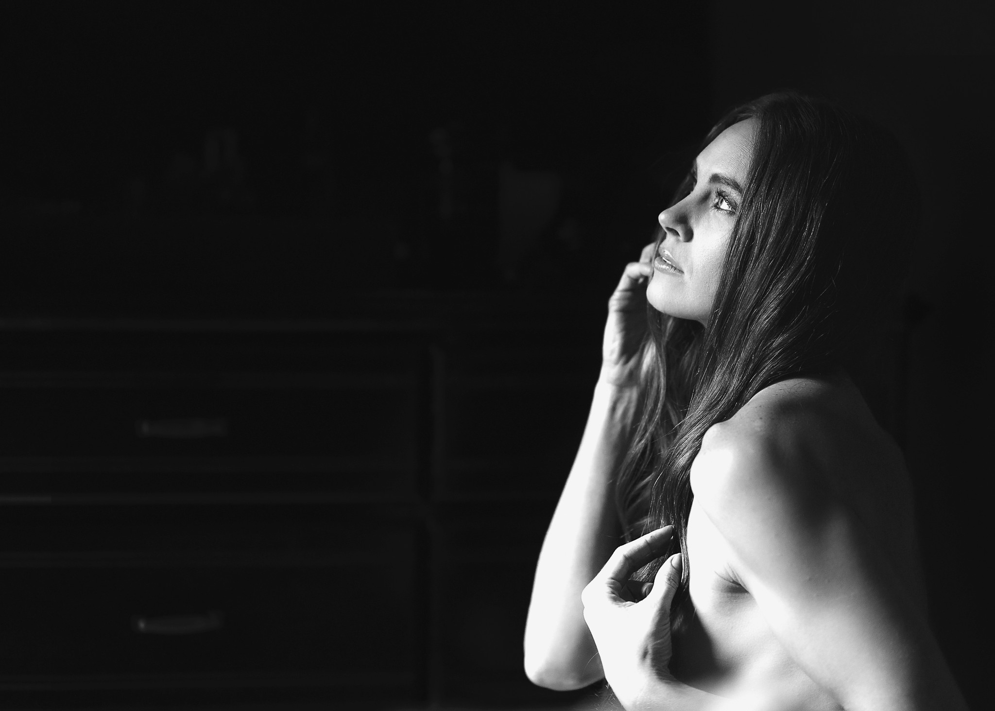 A grassy field with flowers and a tree and a forest in the background on a starry night