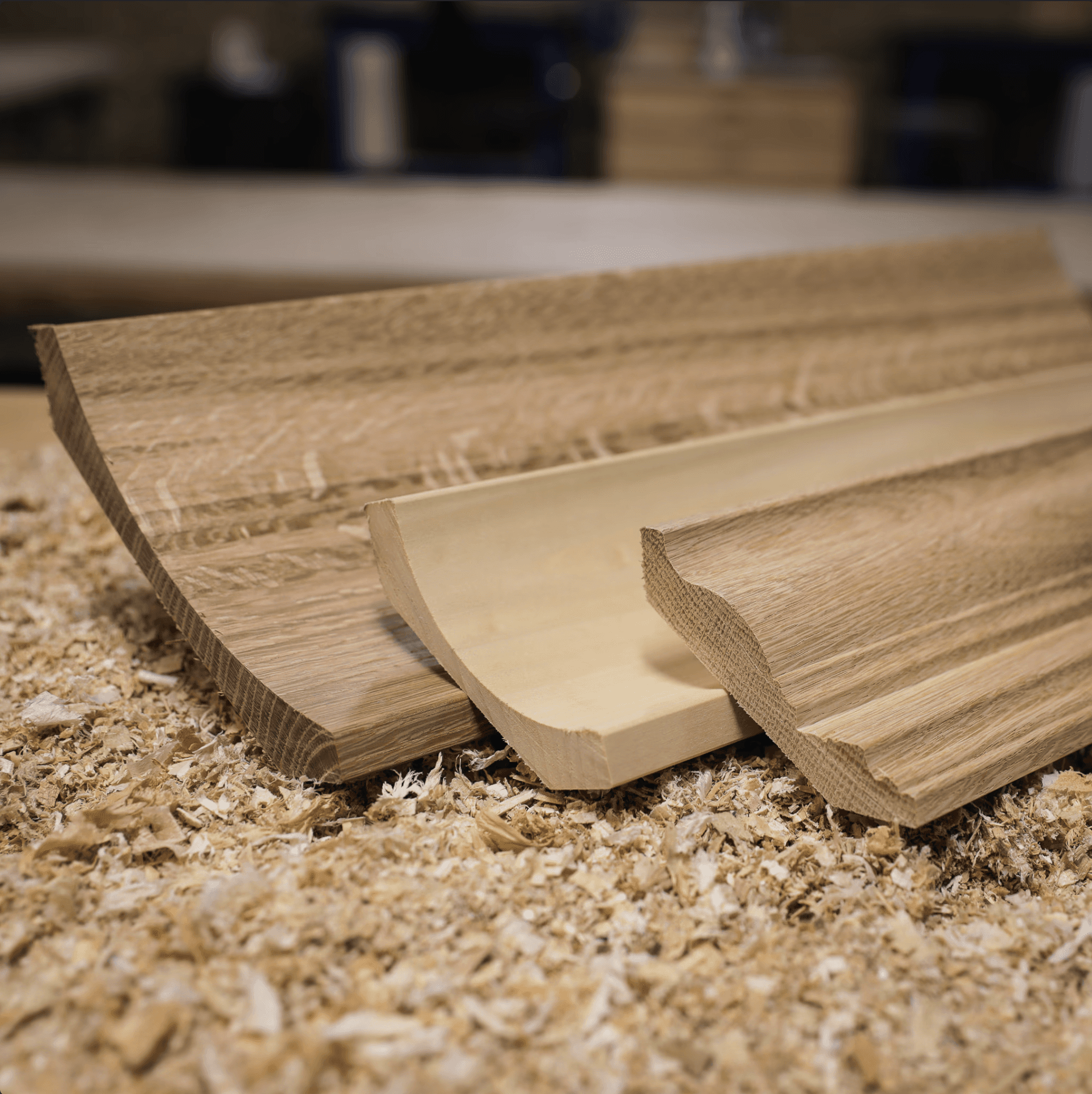 Bright coastal living room with soft natural light, stone flooring, neutral furnishings, and floor-to-ceiling glass opening to an outdoor patio.