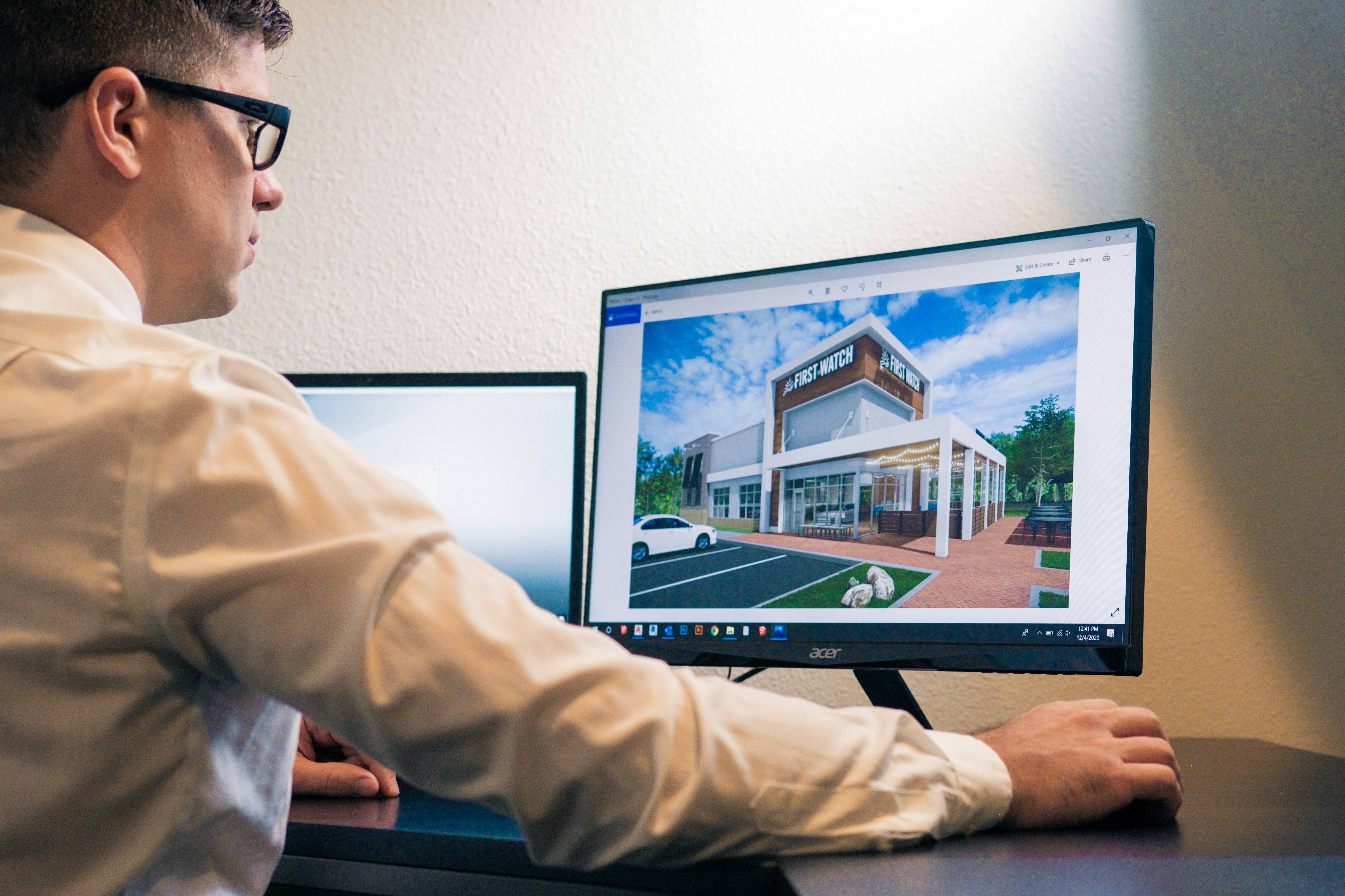 Architect reviewing a building rendering on a desktop monitor