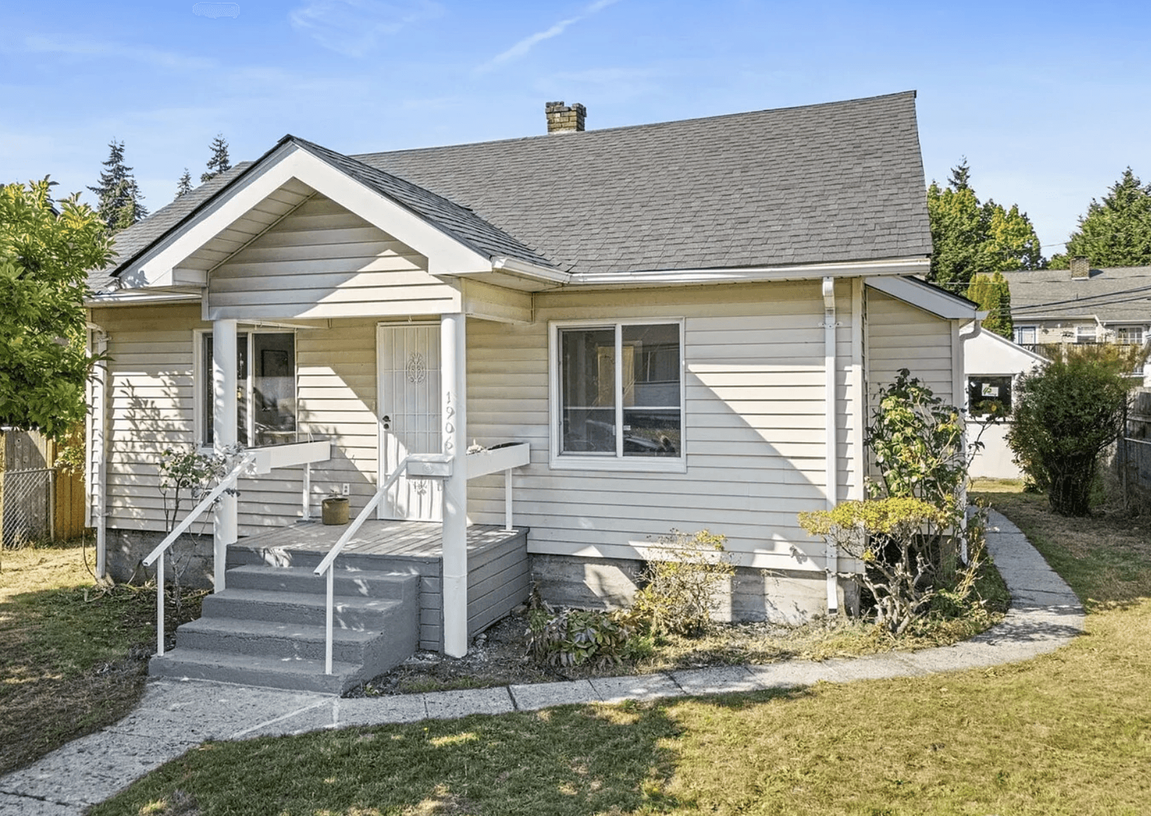Modern luxury house on a hillside surrounded by trees, featuring large glass windows, a terrace, and a small pool at sunset.