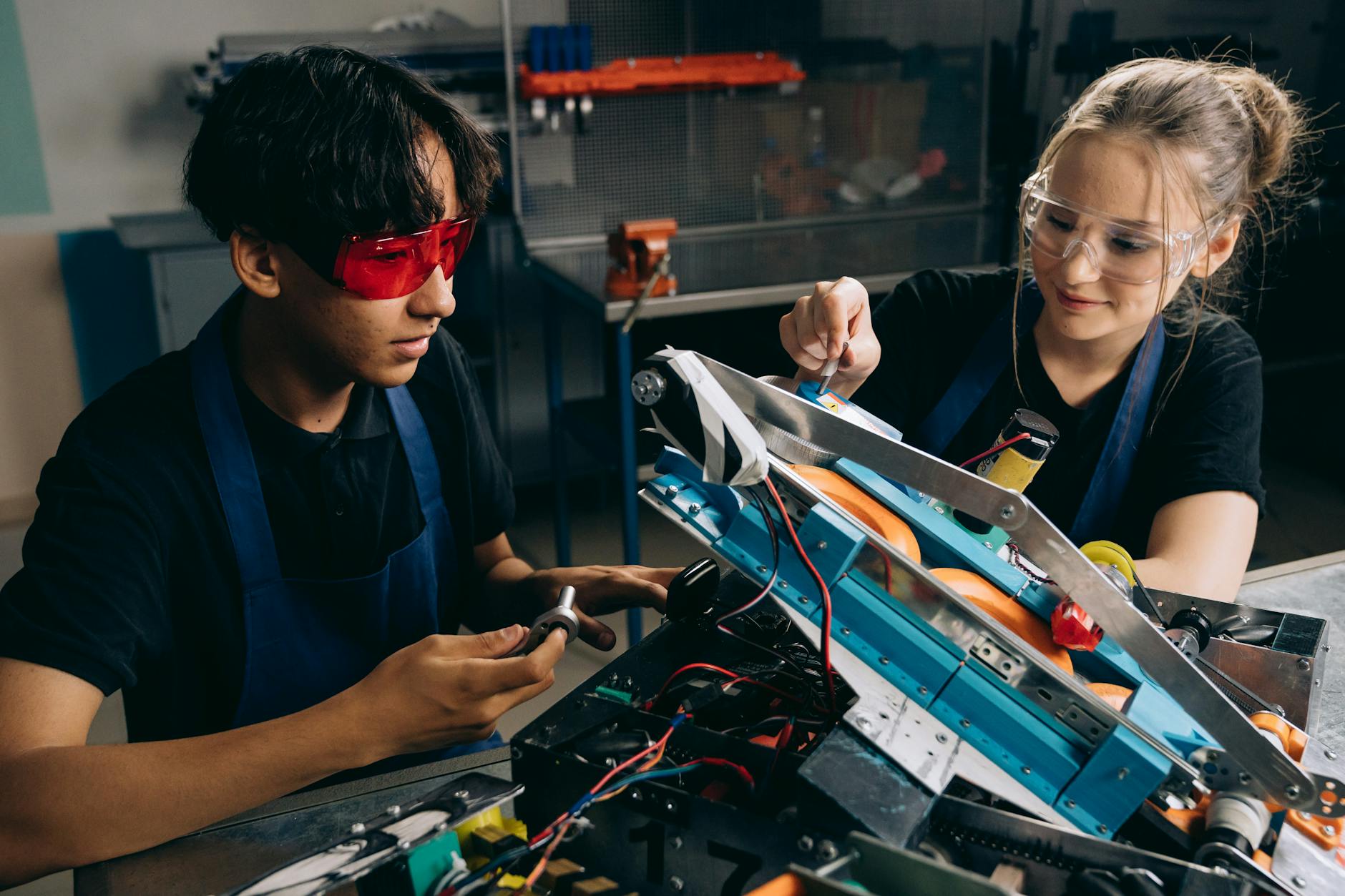 A group of middle school students huddled around a cardboard bridge prototype during a collaborative building project.