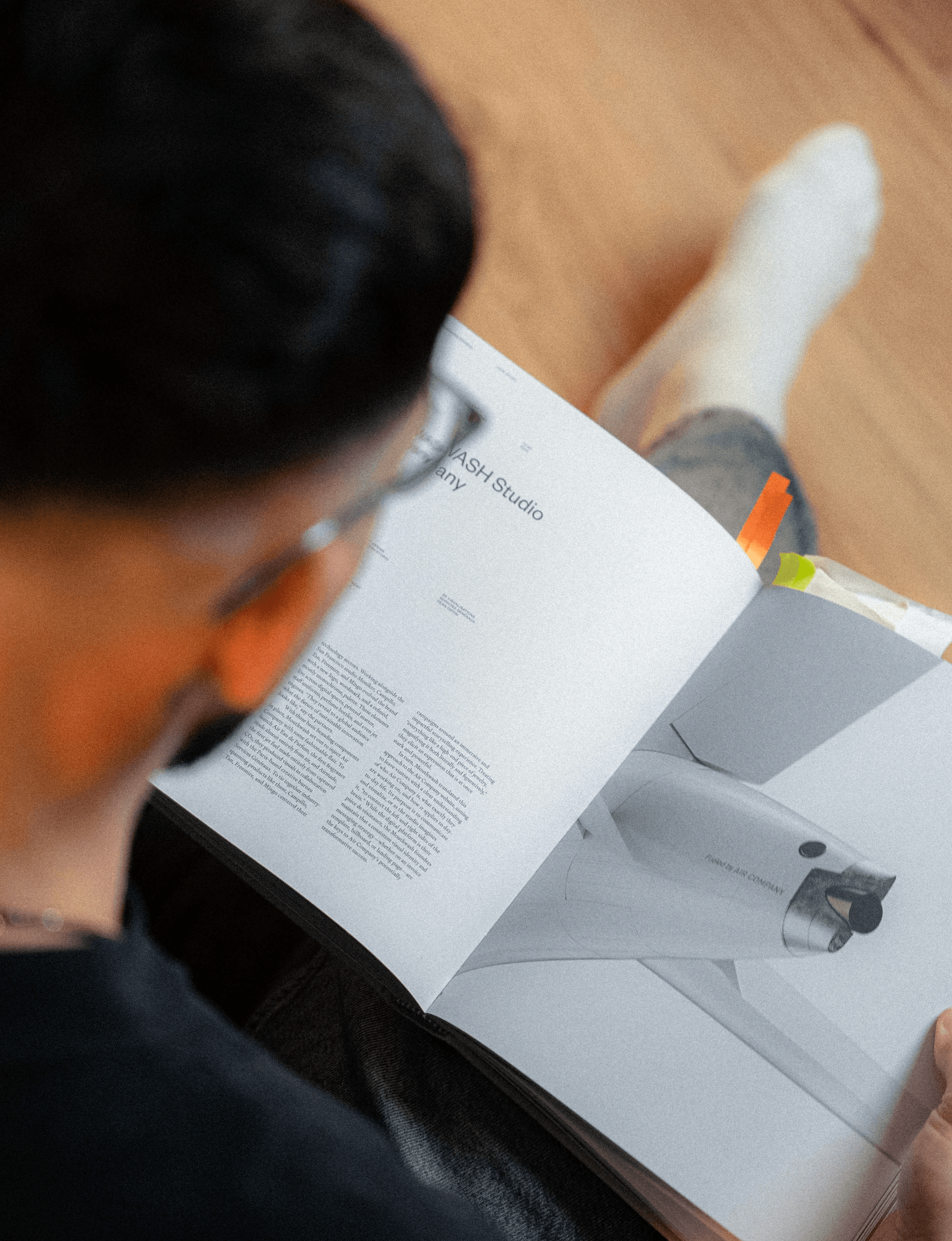 Designer reading a brand strategy document, studying reference material for a client project at Hival Design