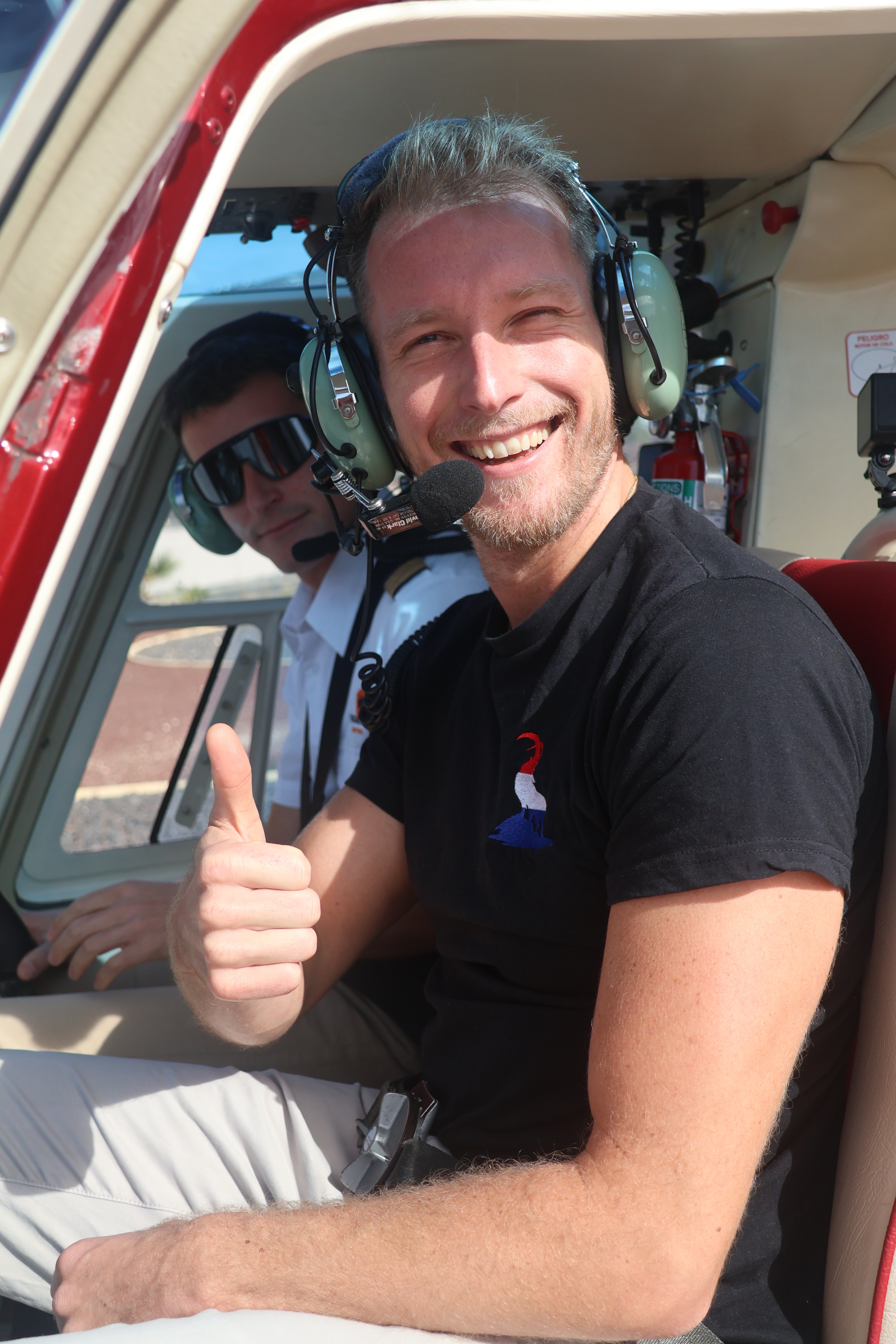Portrait of a laughing person with curly hair wearing a white shirt