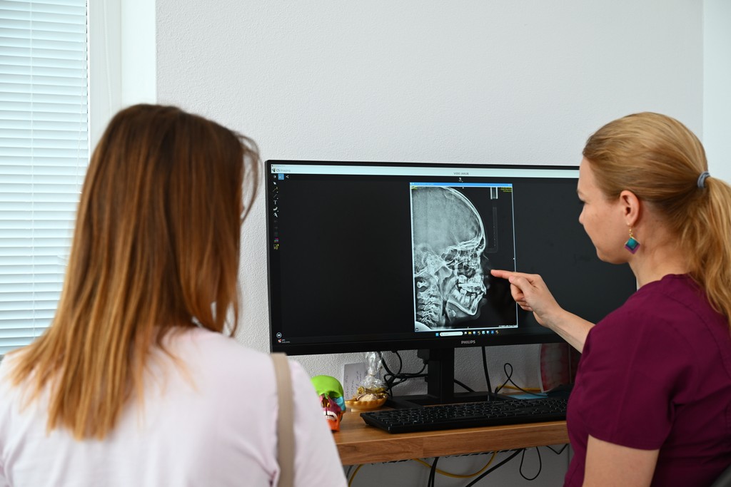 Doktorka vysvetluje rodičom čeľustnoortopedickú liečbu na RTG snímke