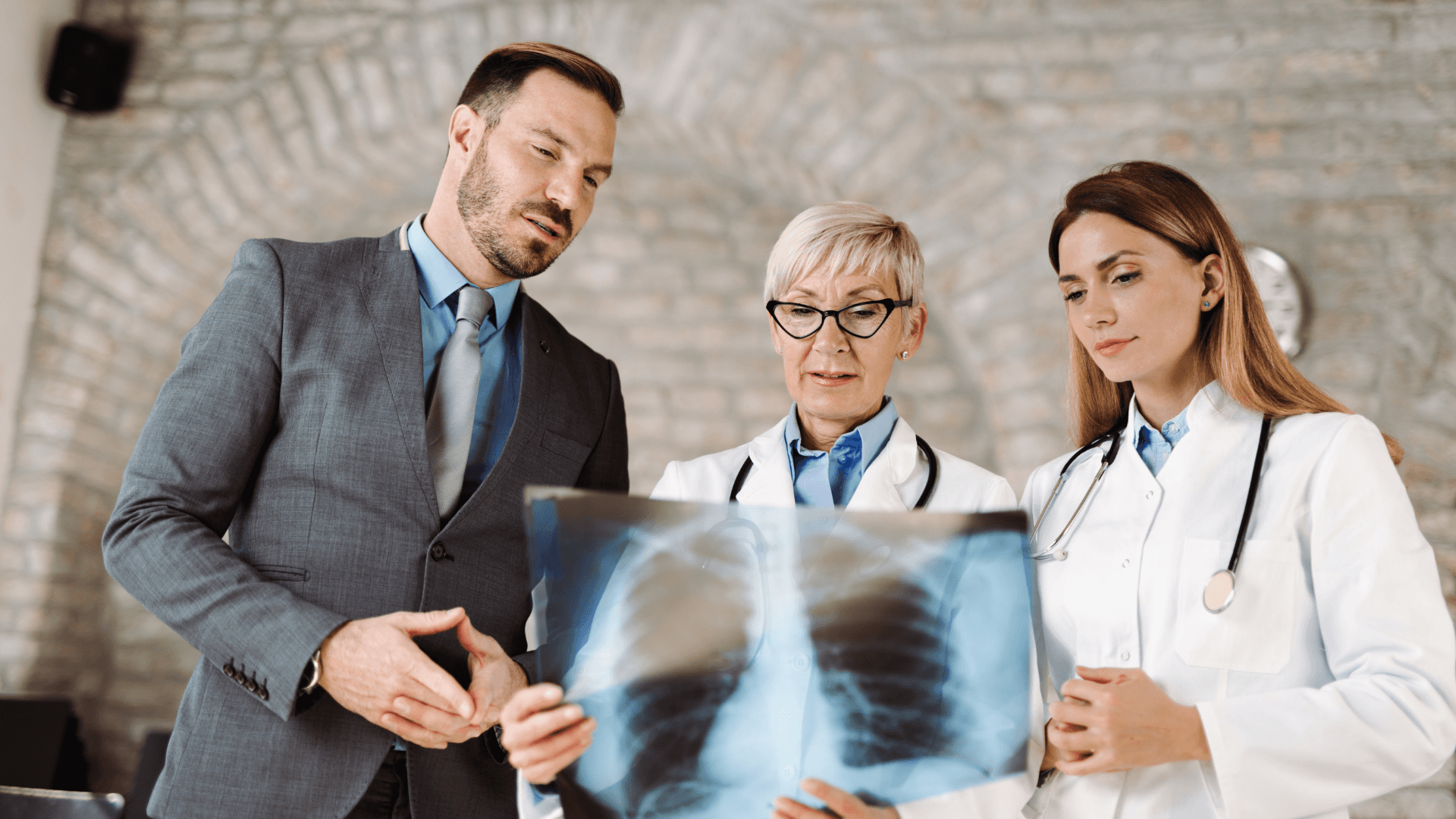 Plaintiff attorney reviewing X-ray results with two expert witnesses to analyze causation in a medical malpractice case