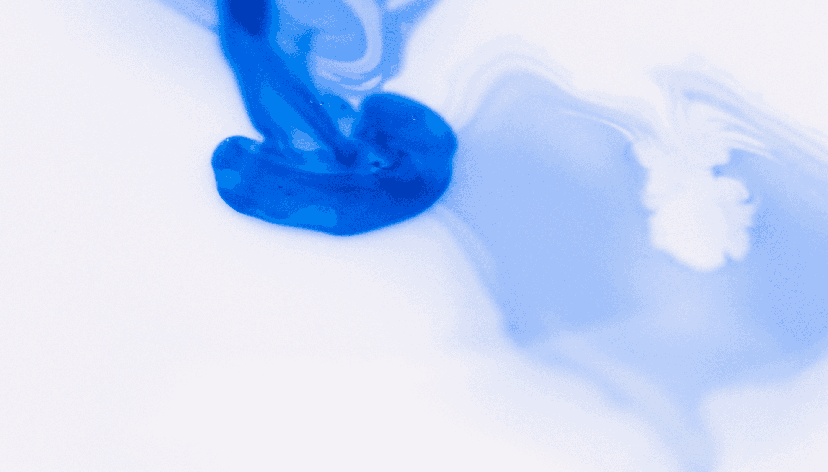 Swirling blue dye in clear liquid.