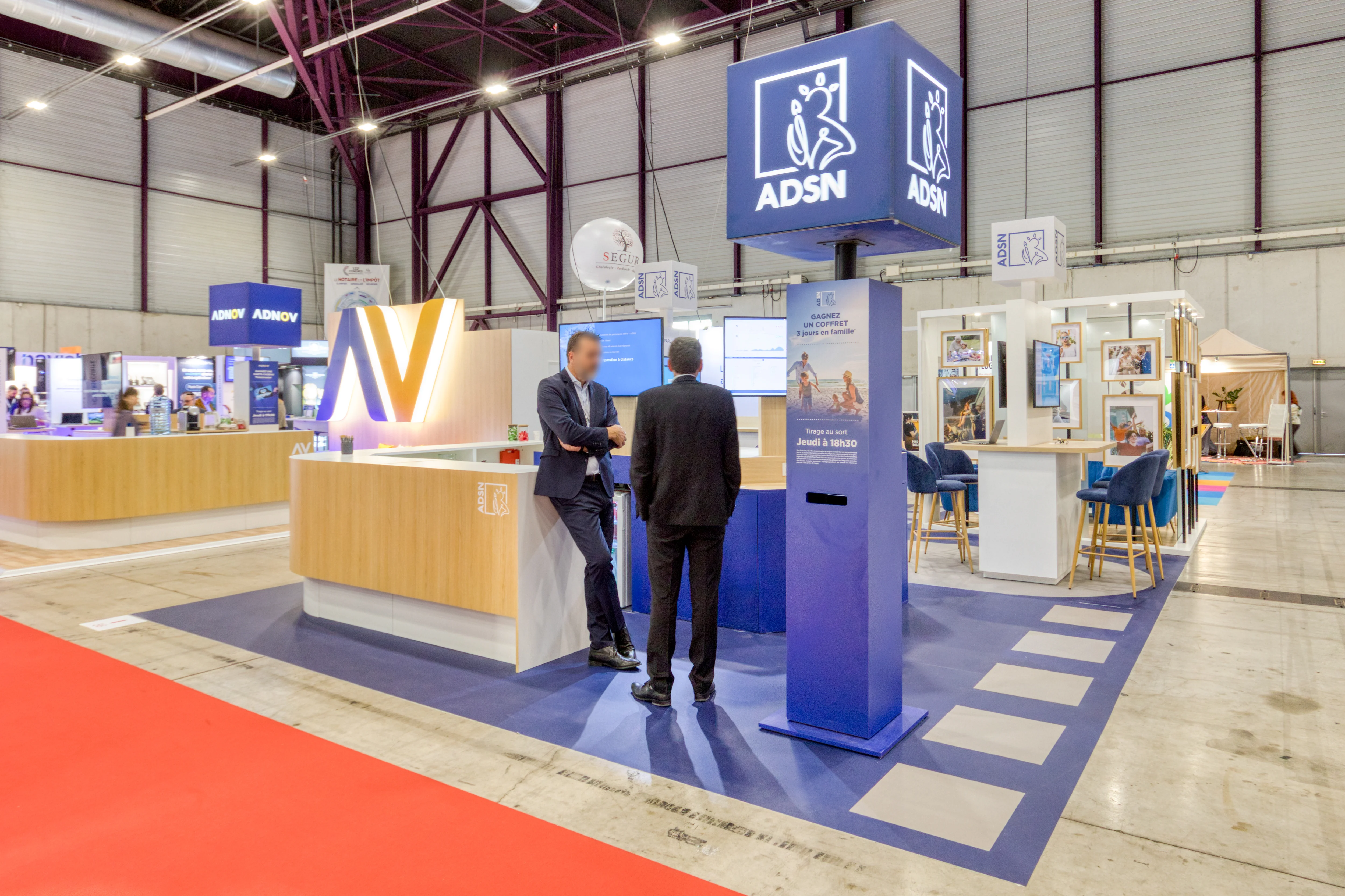 stand ADSN au Congrès des Notaires 2025 à Montpellier avec totem lumineux bleu et accueil Expace