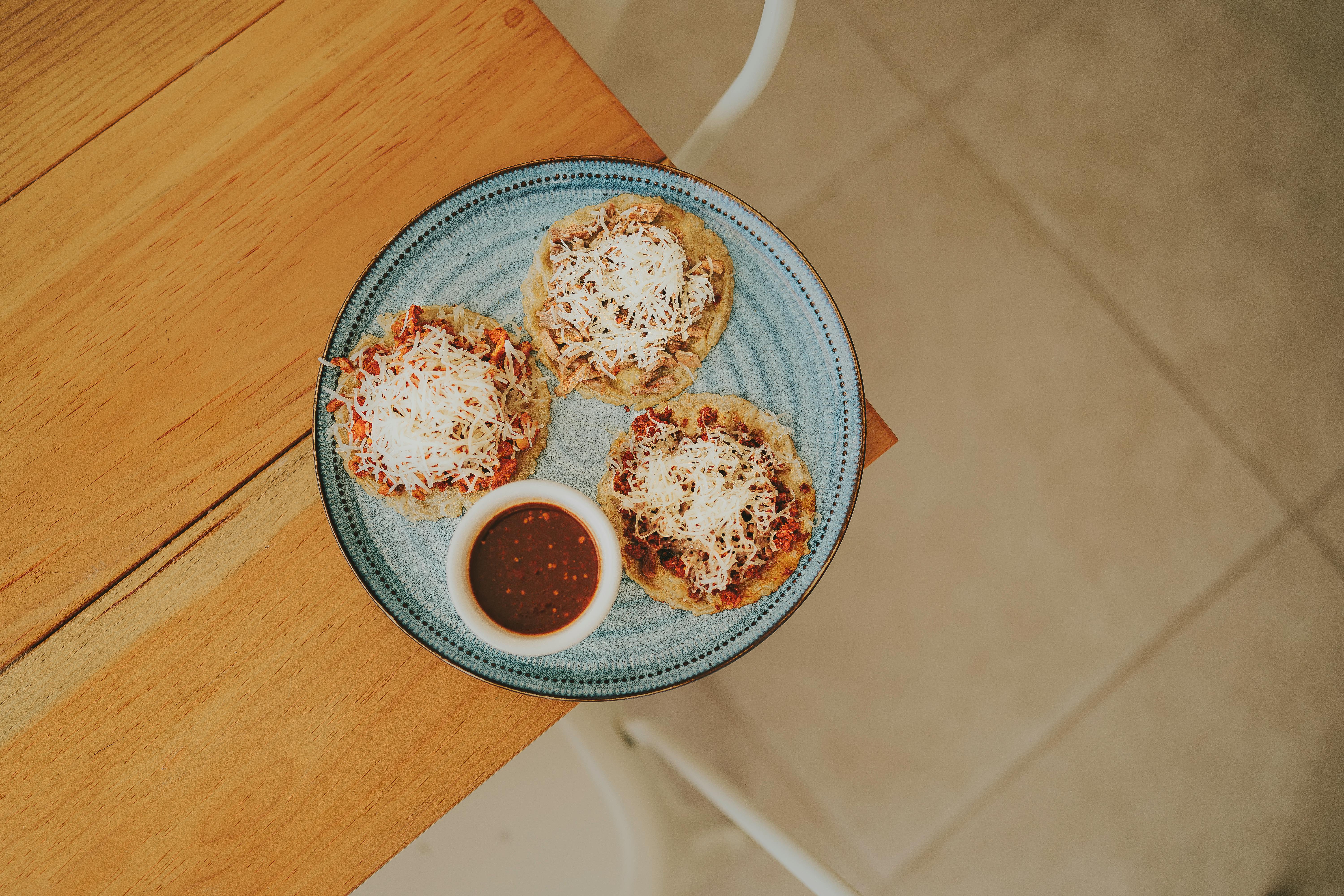 Hand made sopes Handmade thick corn tortillas with a base of beans, topped with lettuce, tomato, cheese, and sour cream.