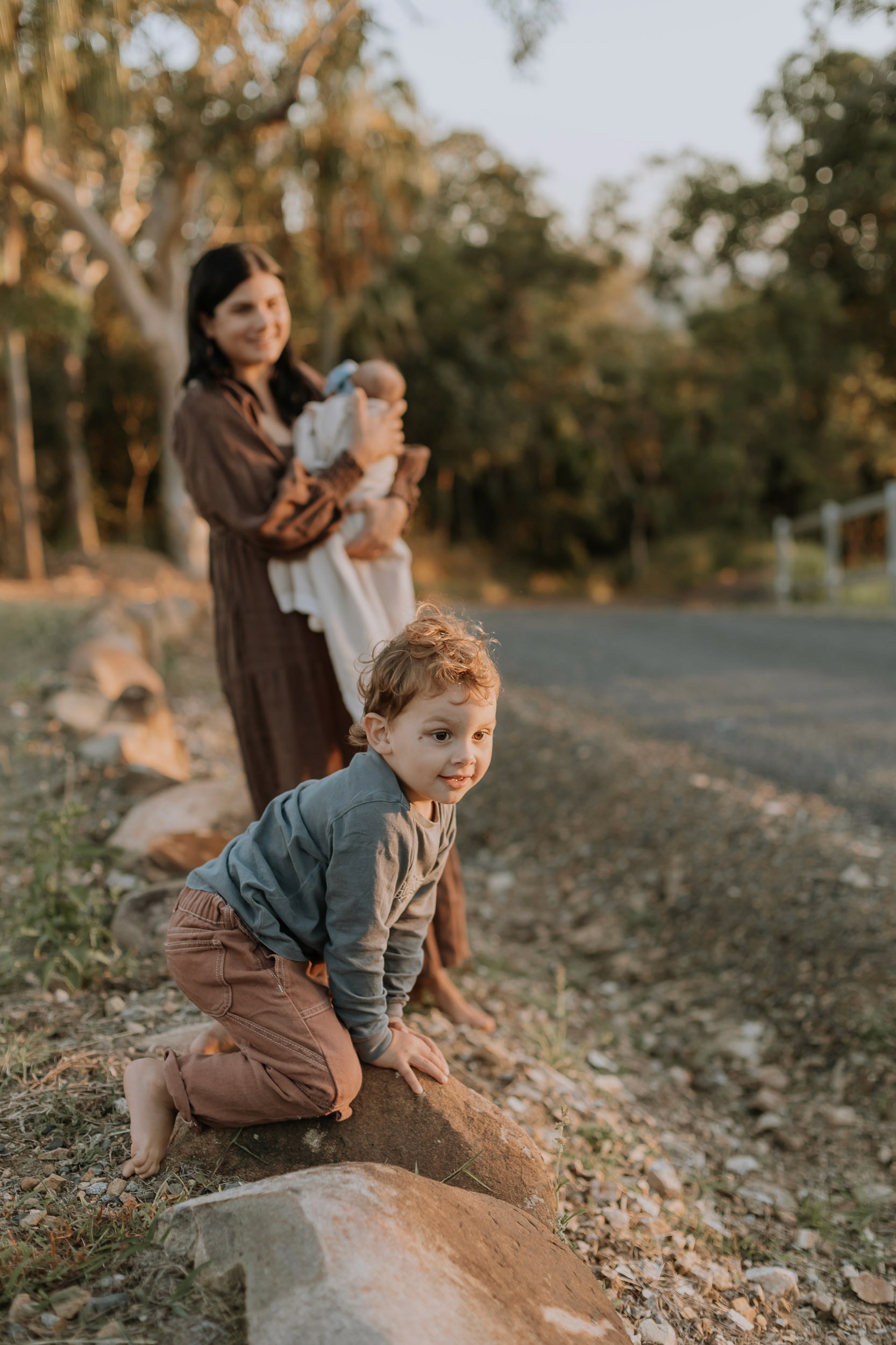 Playful outdoor family session at sunset with kids climbing on rocks