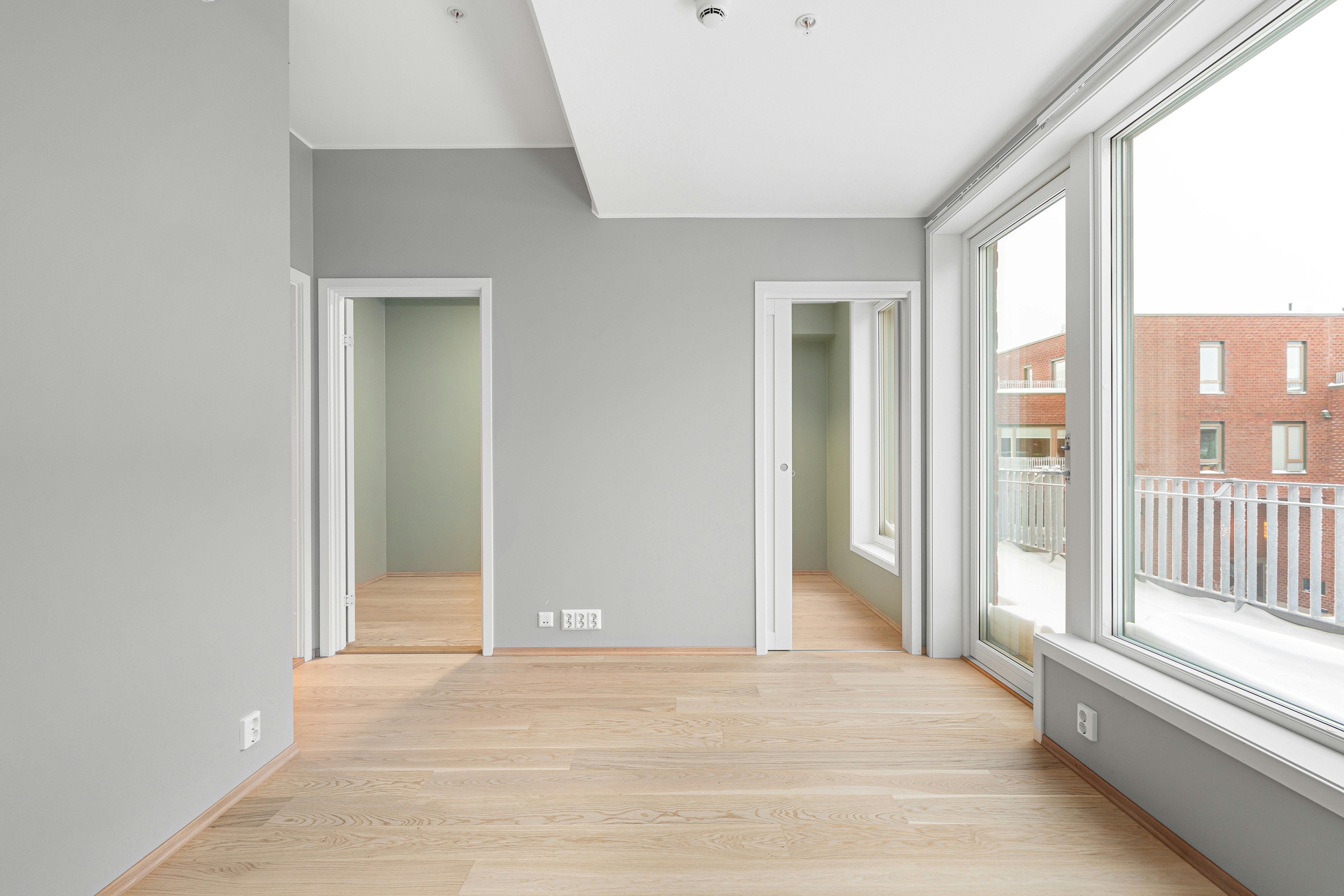 An empty room with a large window and a wooden floor