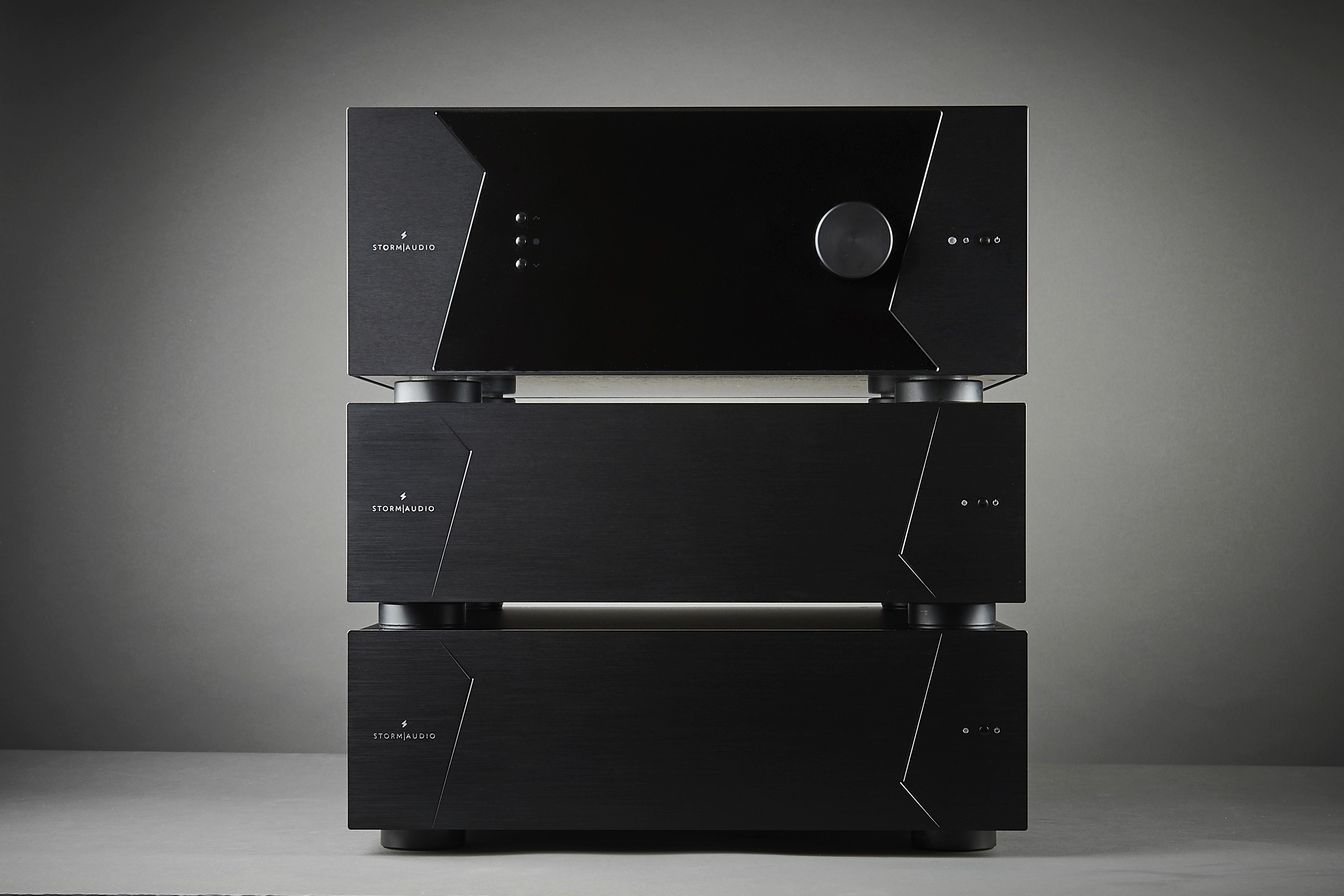 Three black audio amplifiers stacked vertically