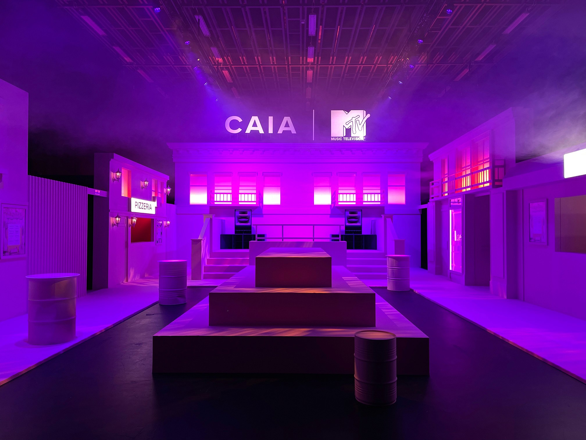 Pink and violet CAIA × MTV event space with branded food and drinks counters