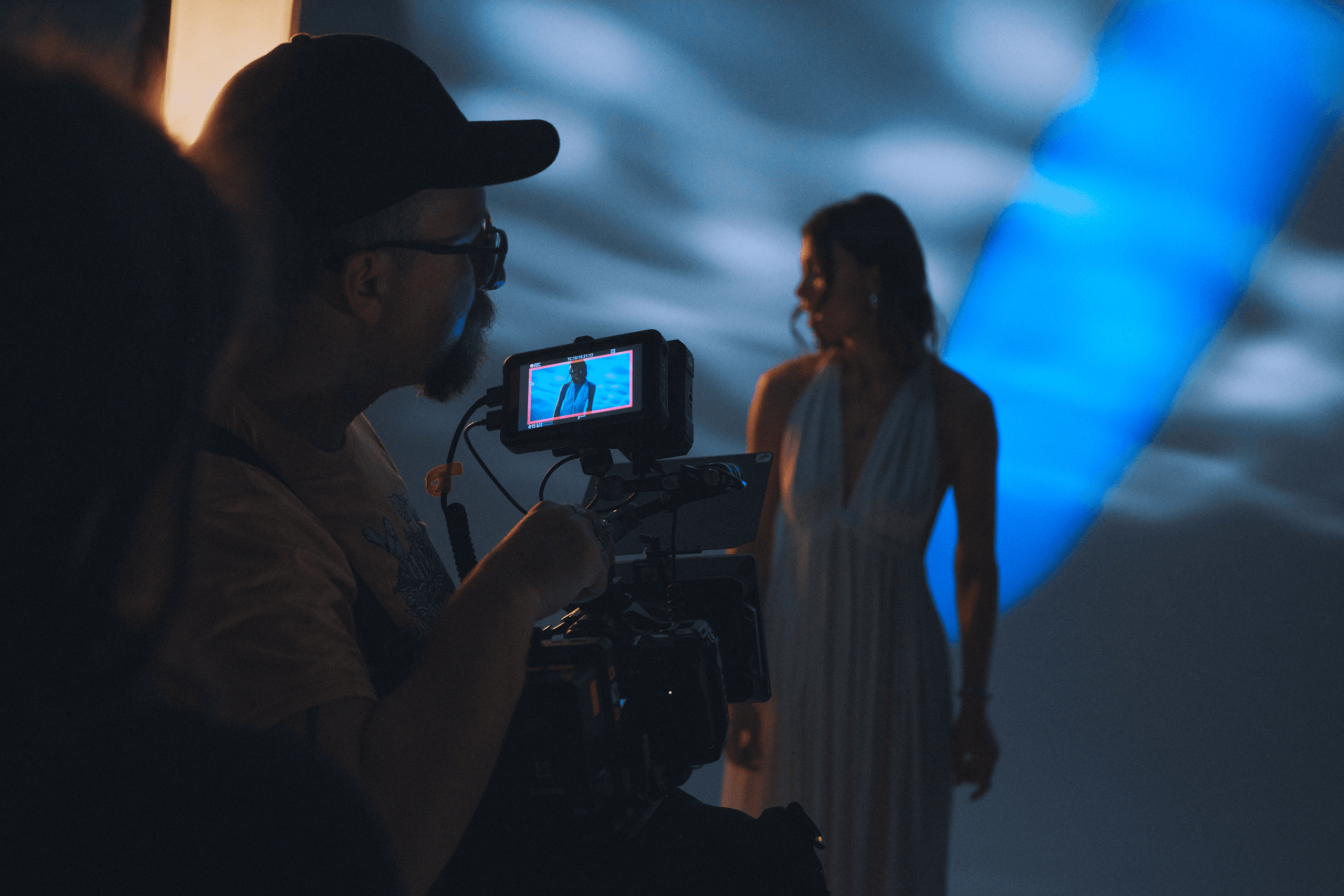 A man is holding a camera and filming a girl.