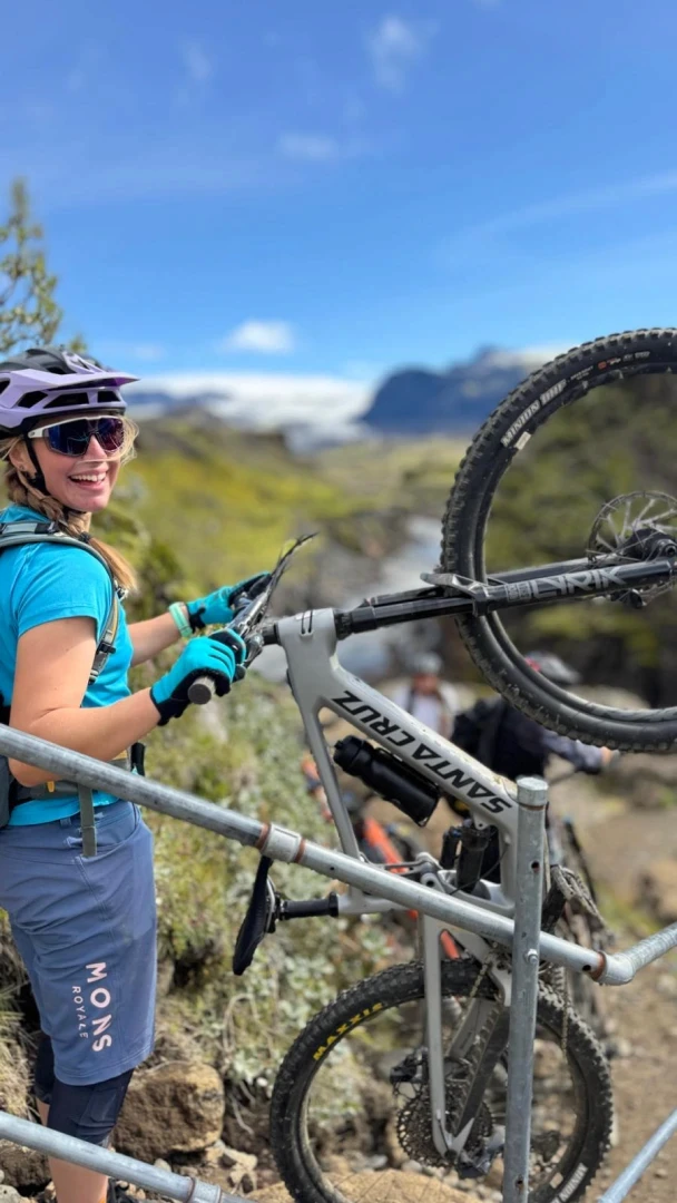 Woman holds her santacruz heckler bike in sunshine with a smile