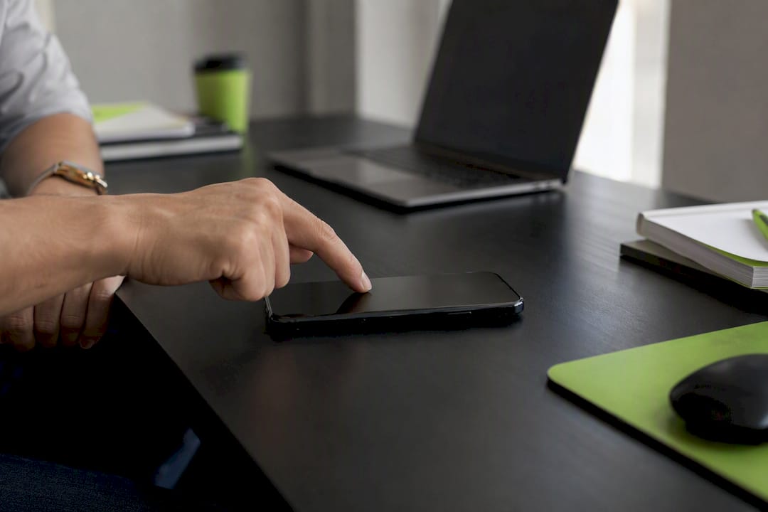 Hand clicking smartphone on desk