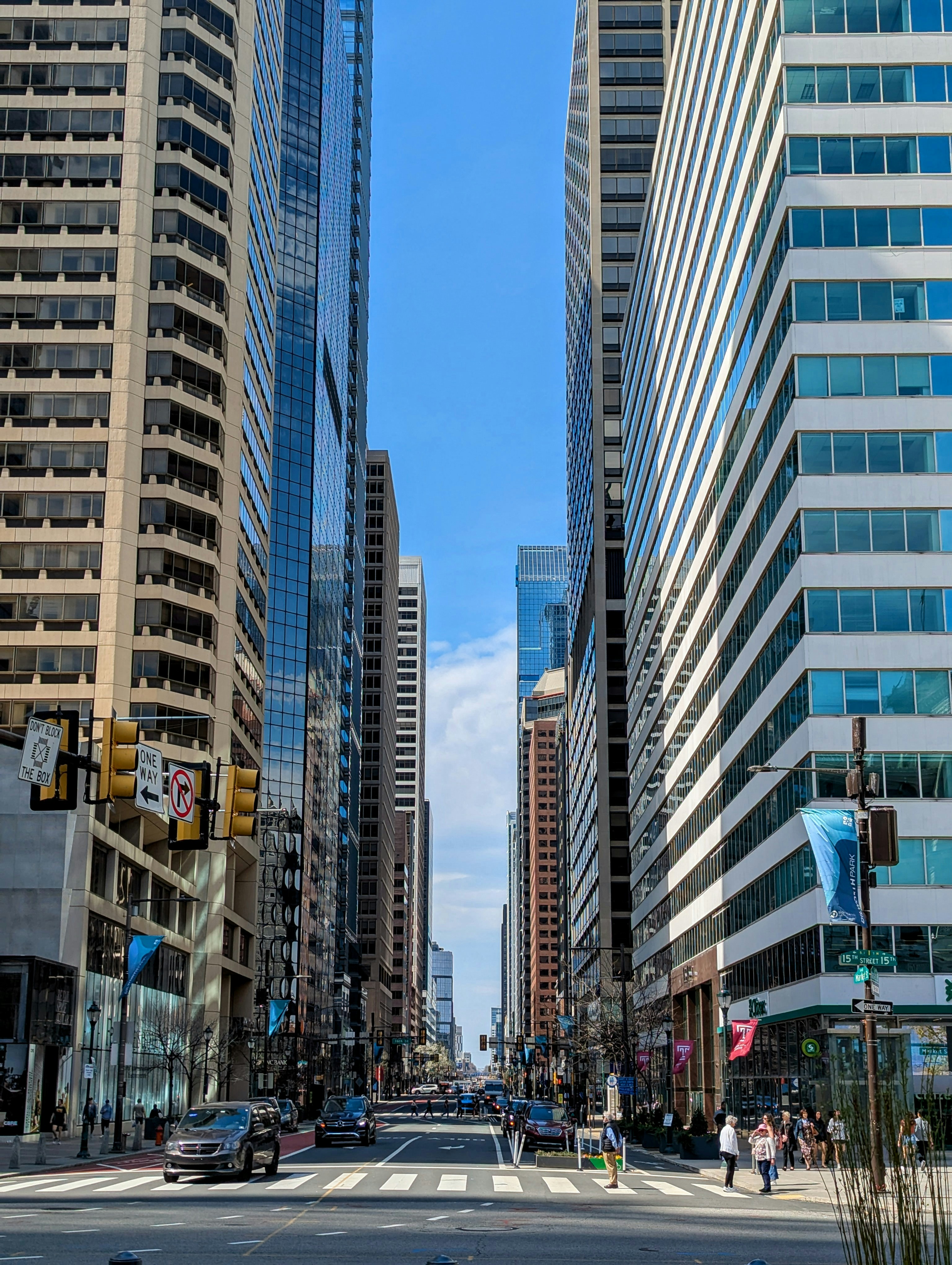 Buildings line a city street under a blue sky.