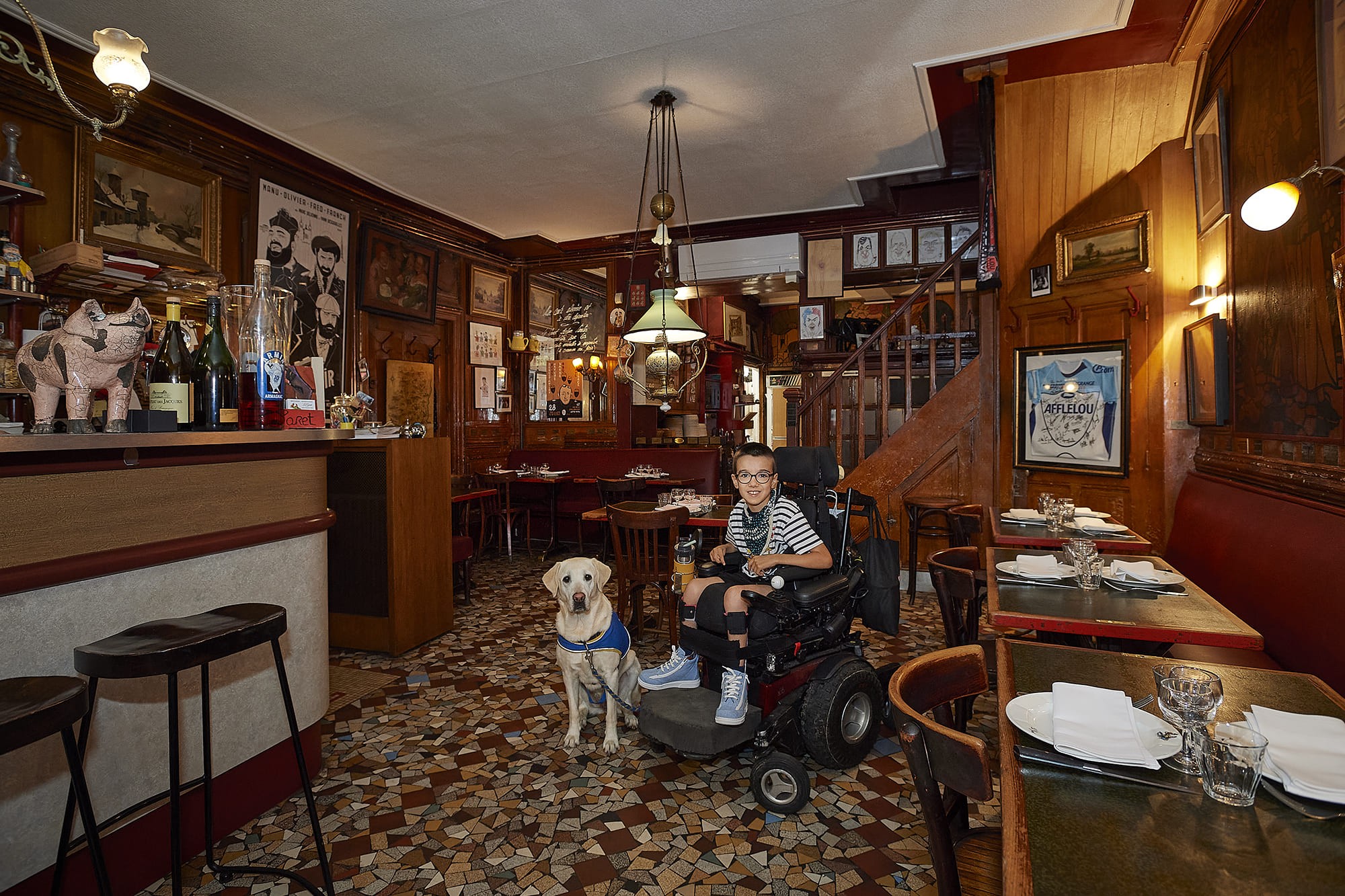 Elias accompagné de sa chienne d’assistance Romy, photographiés par Frédéric Bourcier au restaurant Le Garet à Lyon dans le cadre d’un reportage documentaire social pour Handi’Chiens.