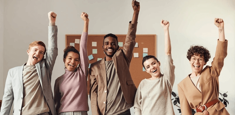 Motivated team celebrating success in the workplace — People Yield employee engagement