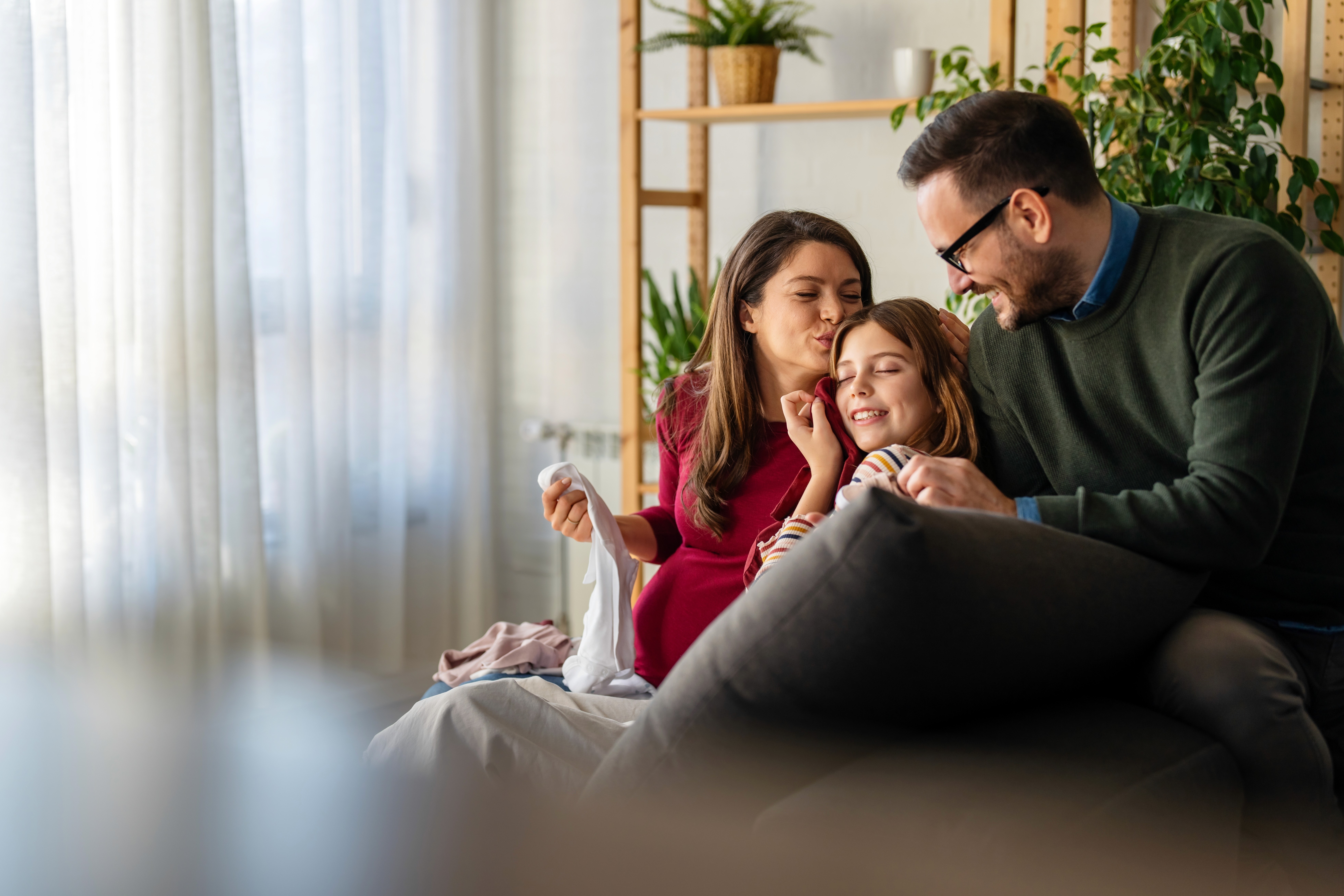 Close-up of hands typing on a laptop keyboard on a wooden desk, with the screen turned off.