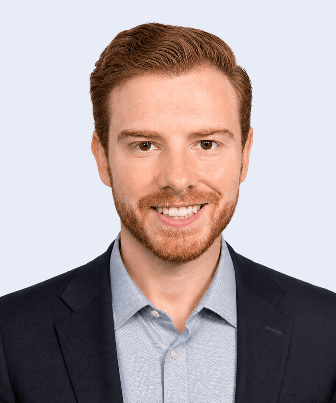 Nick Mariano, Team member, smiling with a light background, in a suit and shirt.