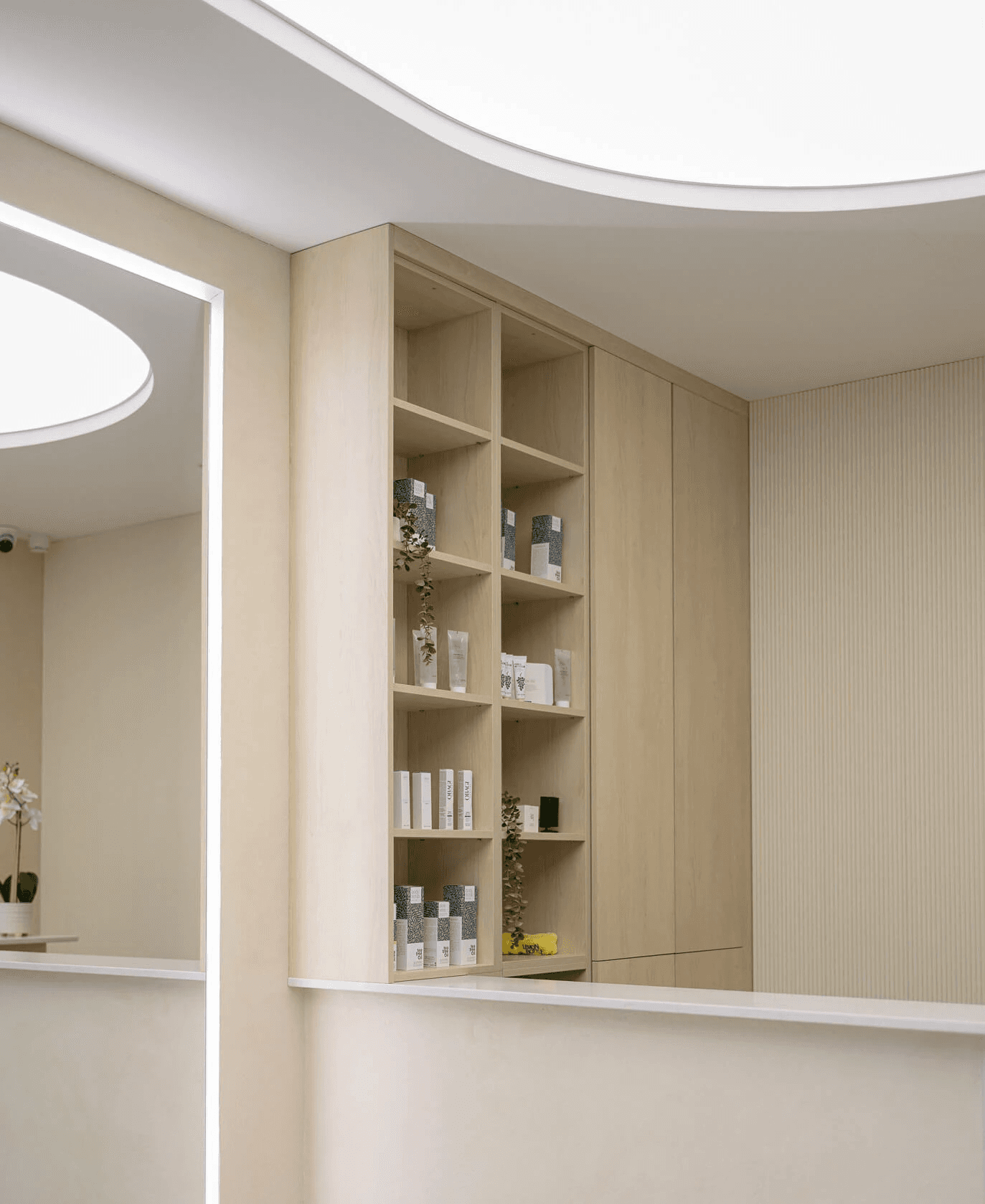 Reception area with skincare product shelves inside a modern aesthetic clinic.