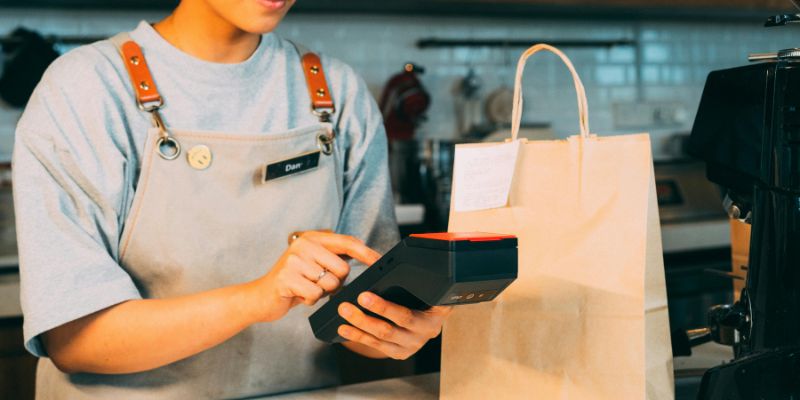 A Malaysian F&B staff member getting payment from a customer