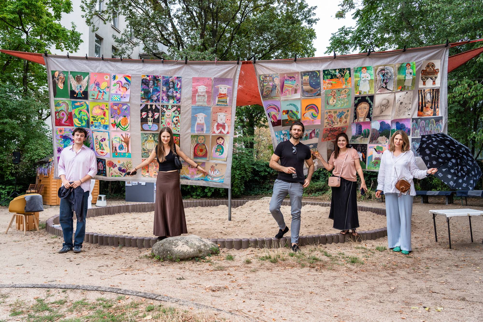 Gäste vor den Bannern mit Kinderzeichnungen – Fest zum 20. Geburtstag von Nezabudka