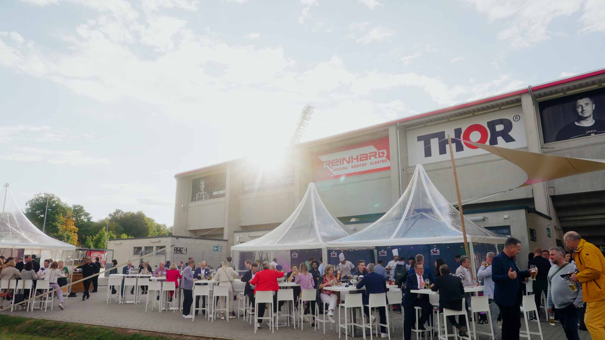 Outdoor event gathering, featuring guests under white tents, ideal for filmproduction, ads, and social media campaigns.